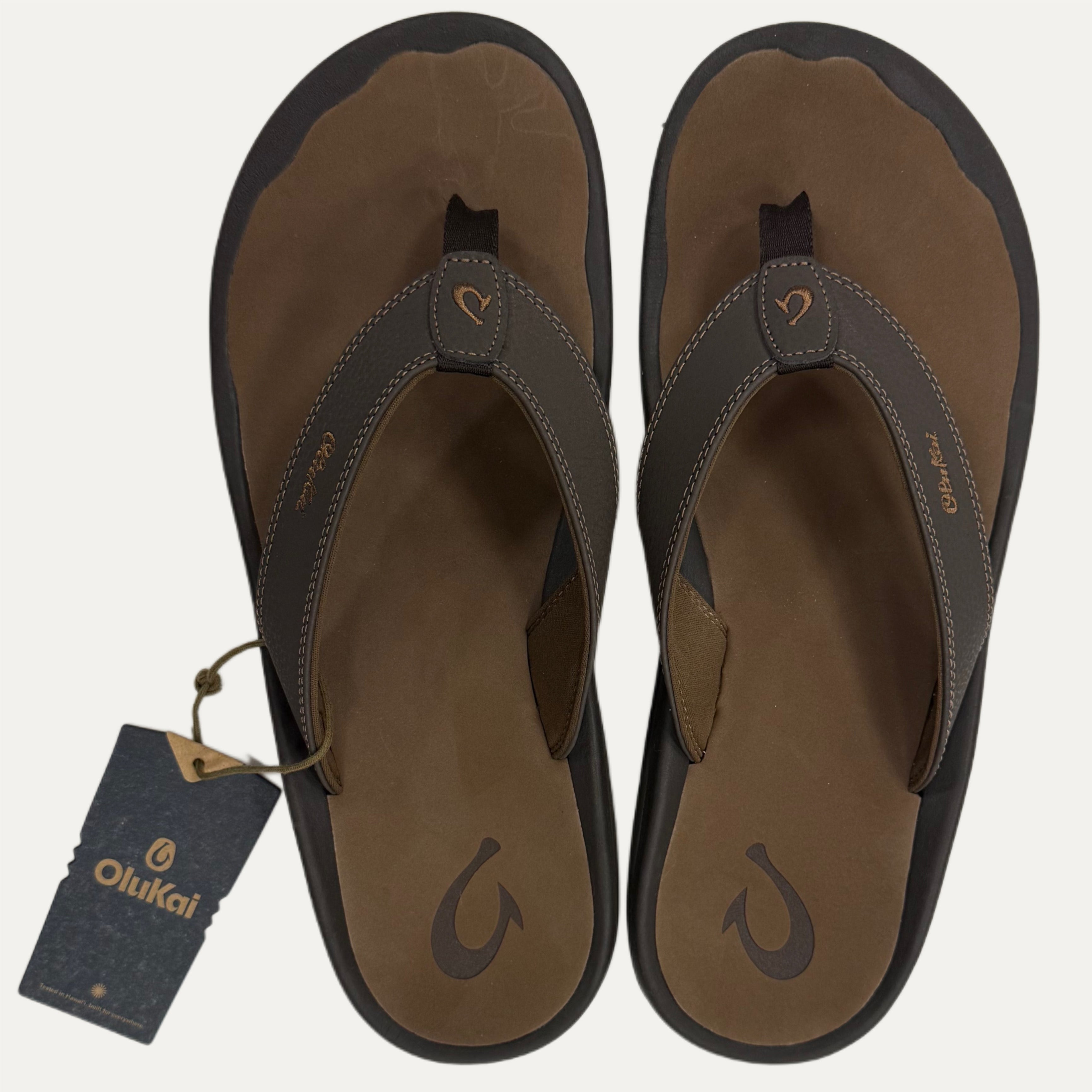 Brown flip flops with a tag on a white background