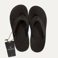 Pair of dark brown flip flops with a visible brand tag.