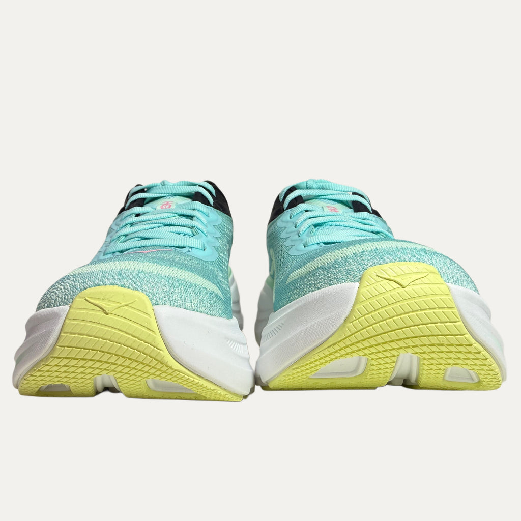 Pair of mint green hoka bondi  9 running shoes with yellow soles on a white background