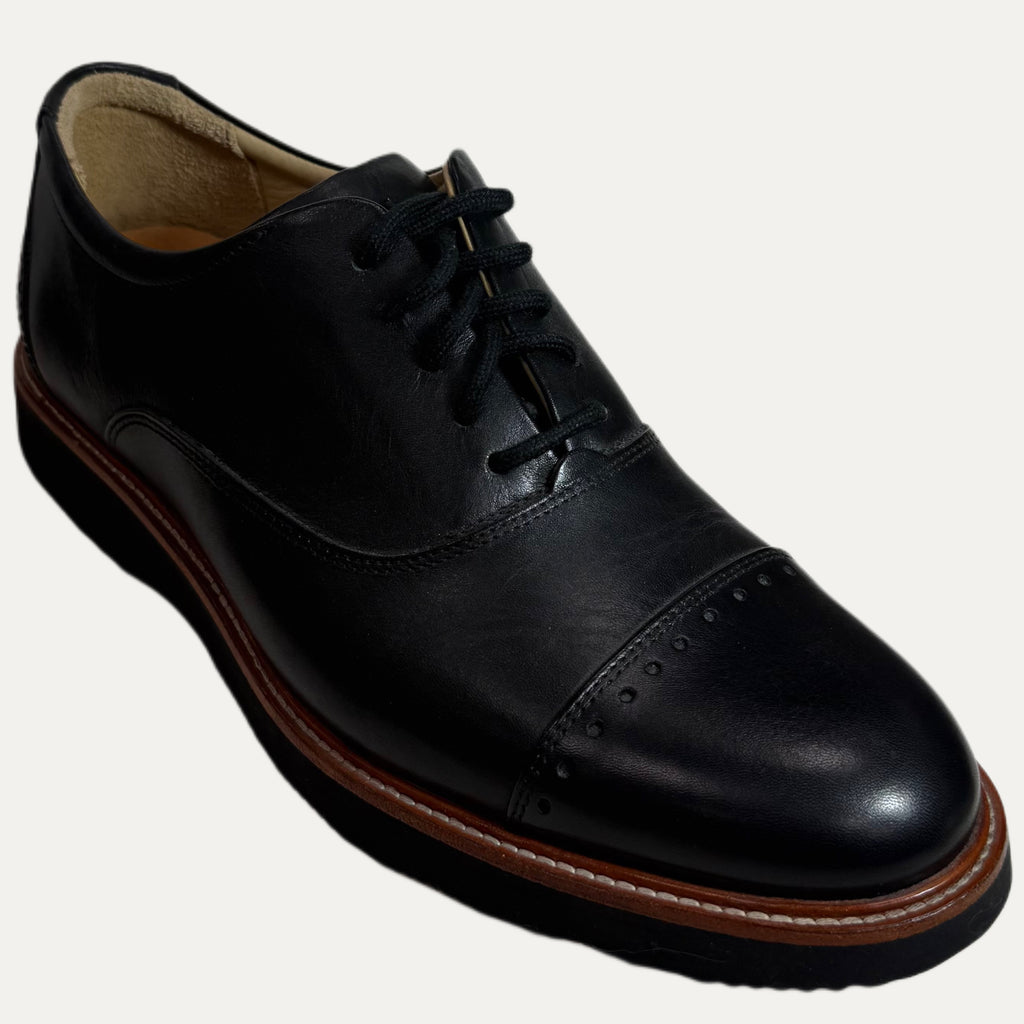 Black leather dress shoe on a white background