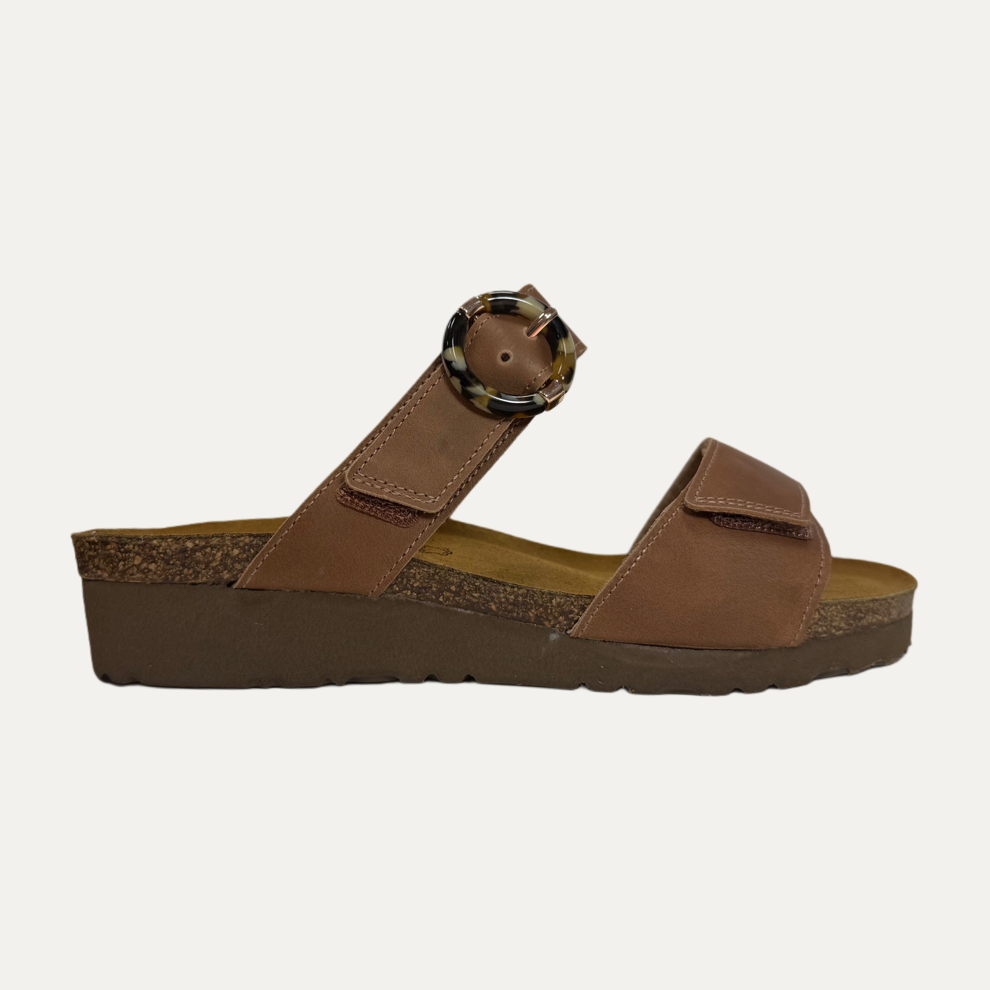 Brown sandal with a strap and decorative buckle on a light gray background