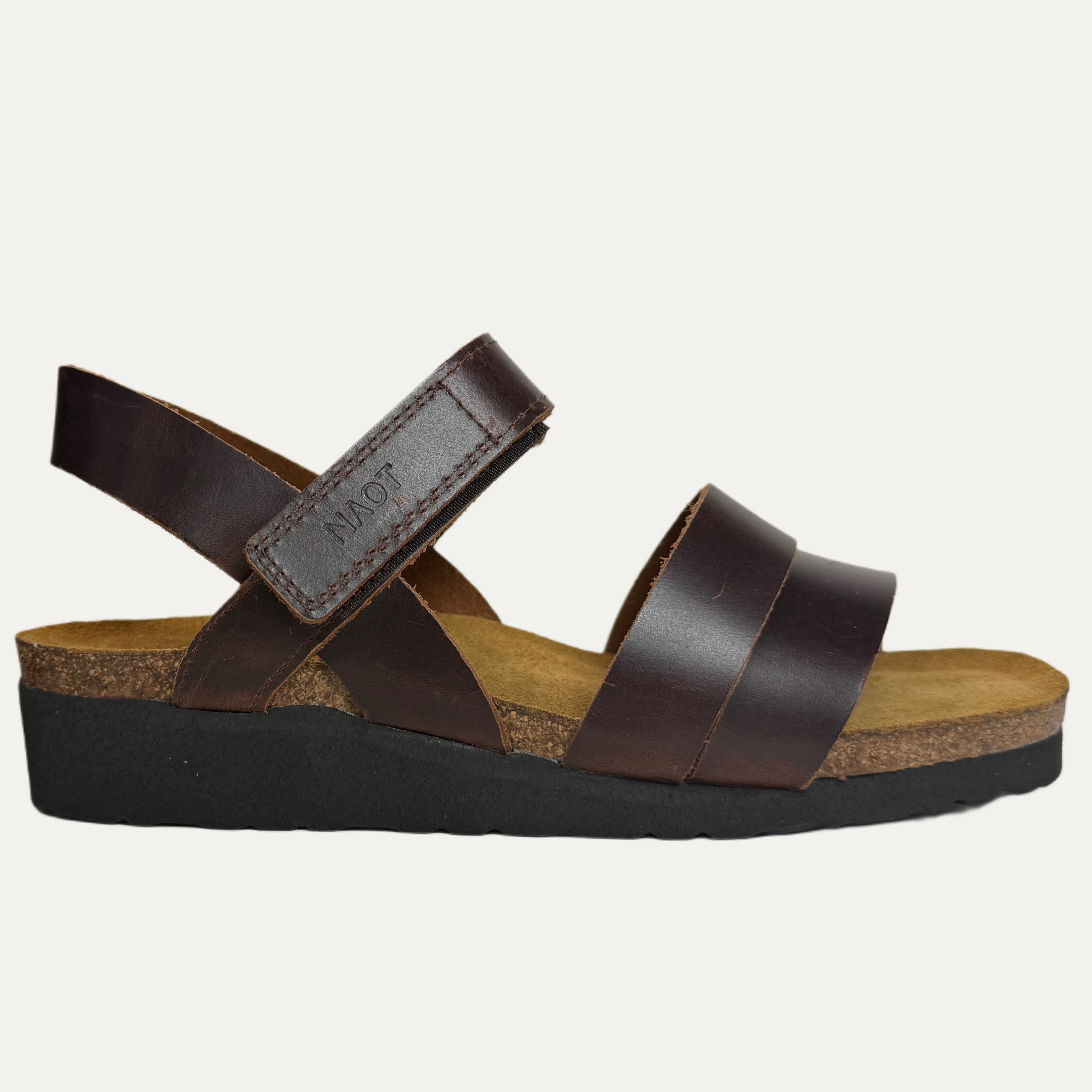Brown sandal with a cork insole and black sole on a white background