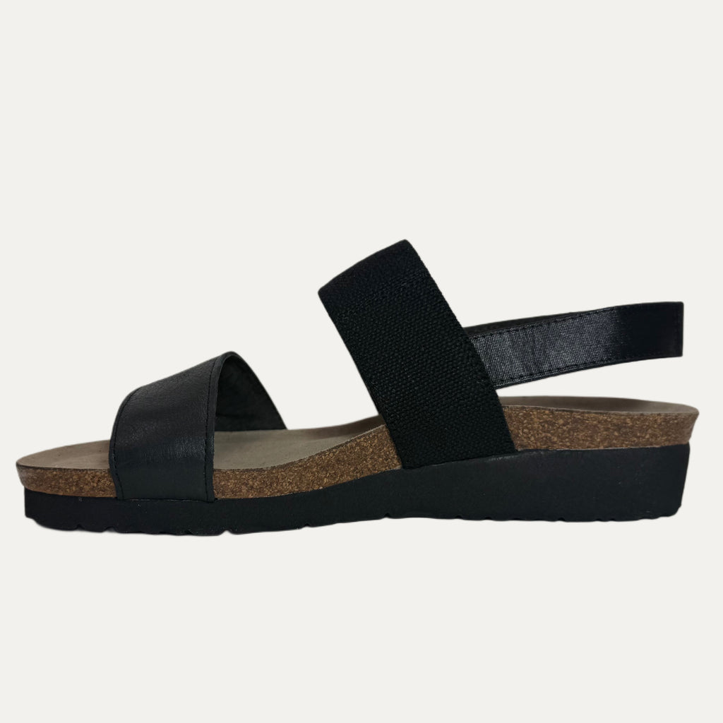 Black sandal with a thick sole on a light gray background