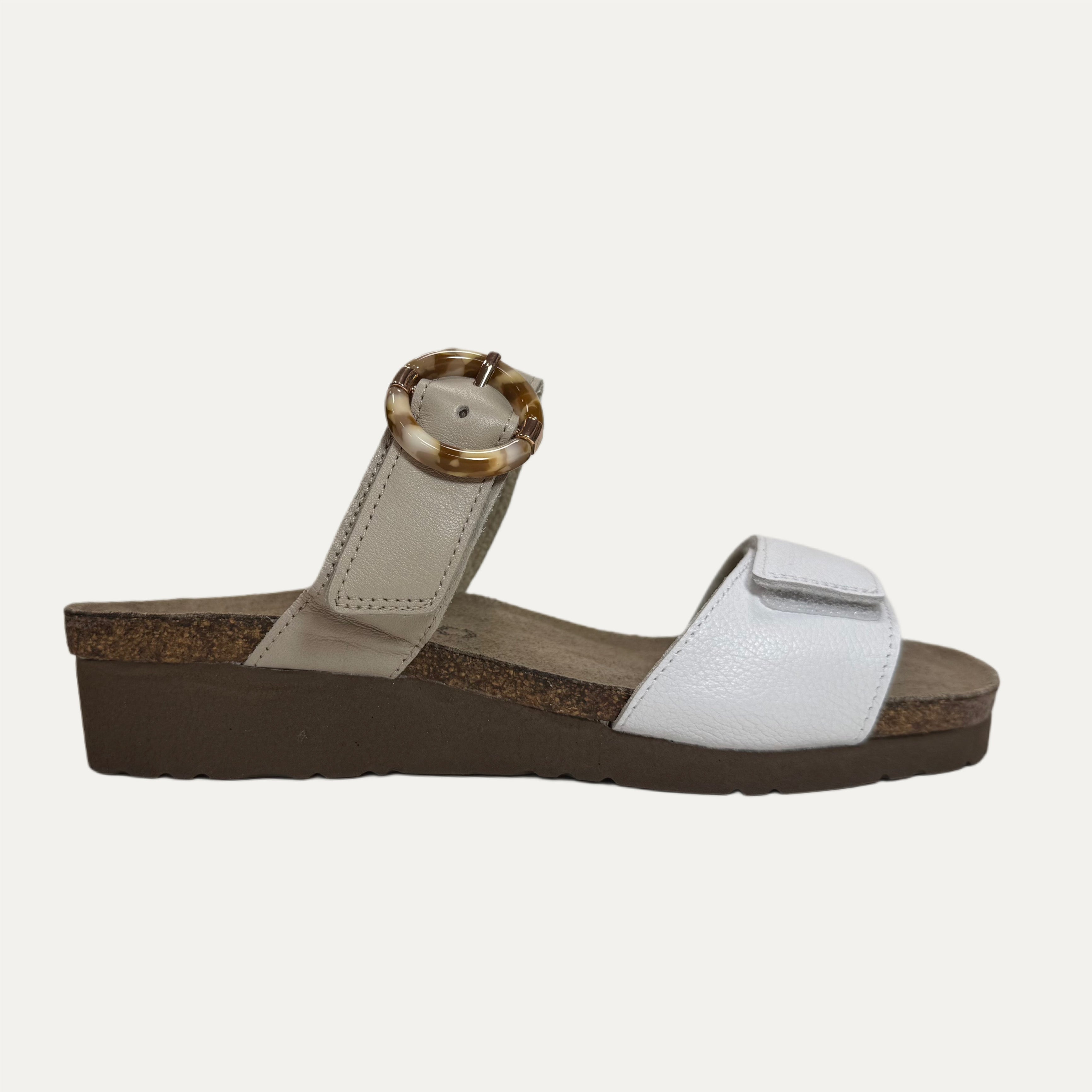 White sandal with a brown sole on a white background