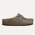 Brown shearling lined clog with buckle and cork sole on a white background