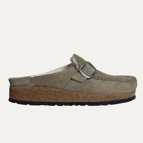 Brown shearling lined clog with buckle and cork sole on a white background