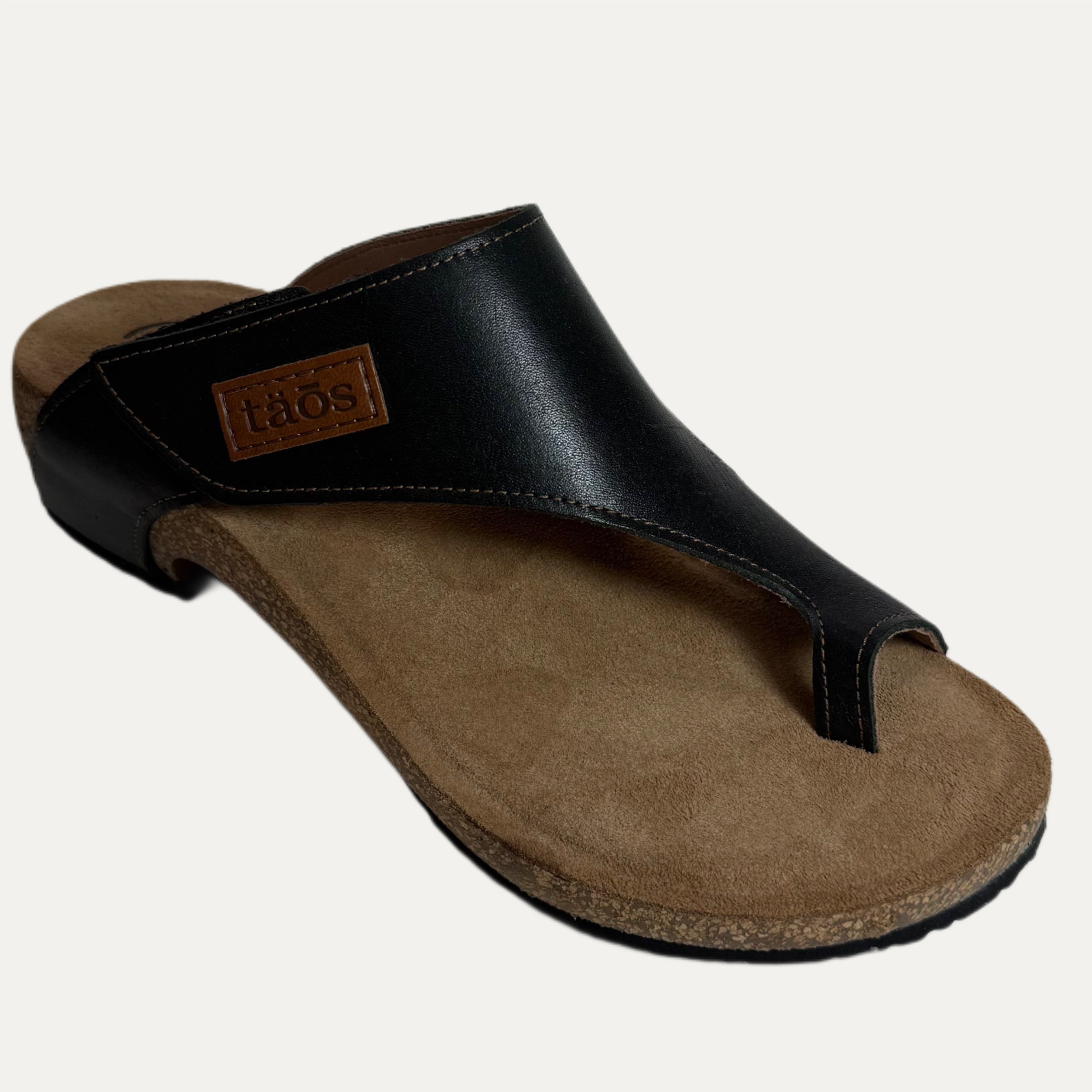 Black sandal with brown cork sole on a white background