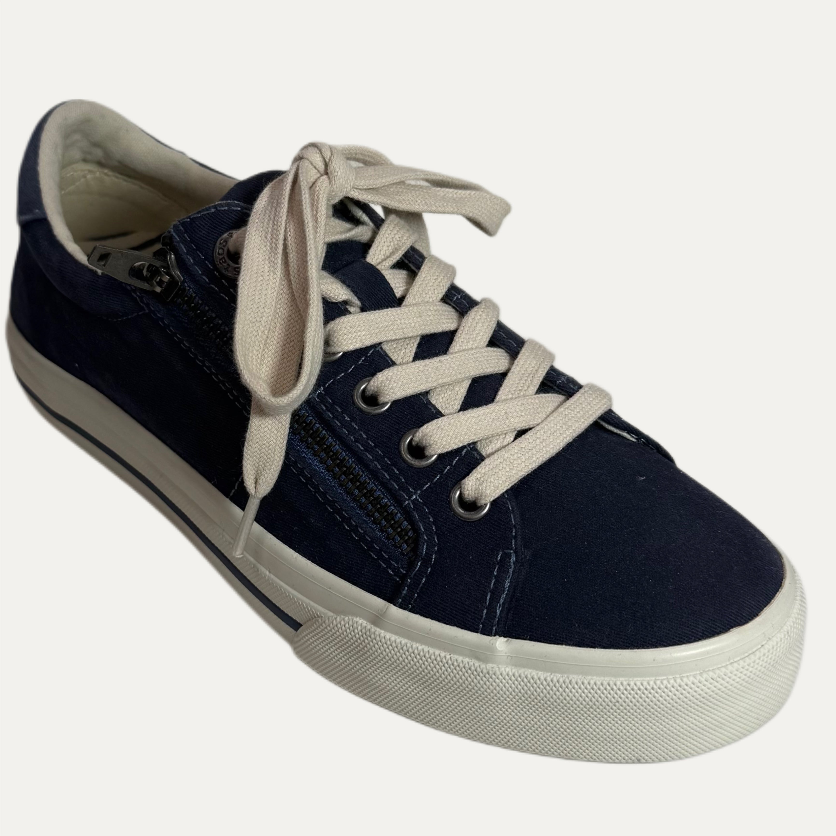 Navy blue sneaker with white laces on a white background