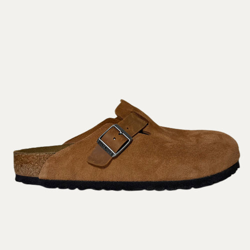 Brown suede clog shoe with a buckle on a white background