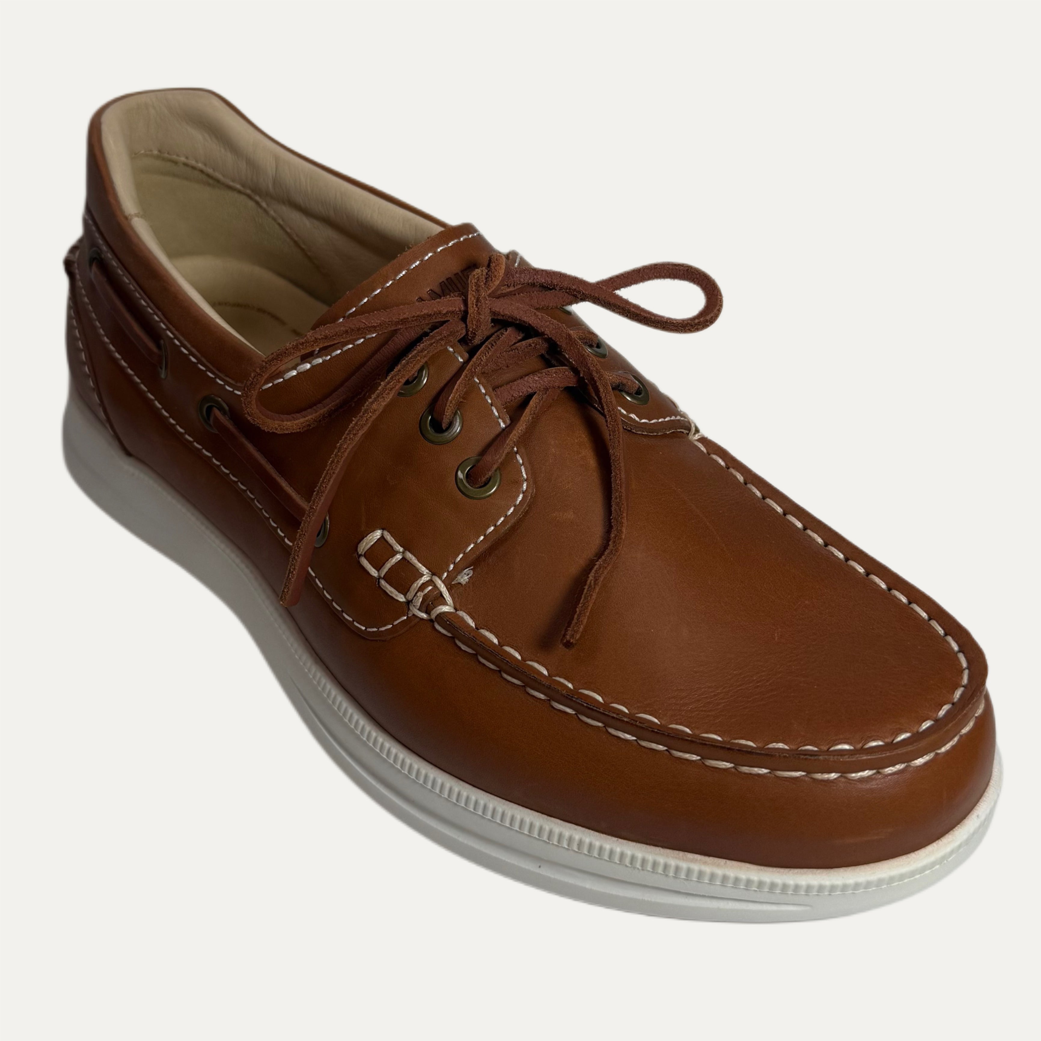 Brown leather shoe with white sole on a light gray background