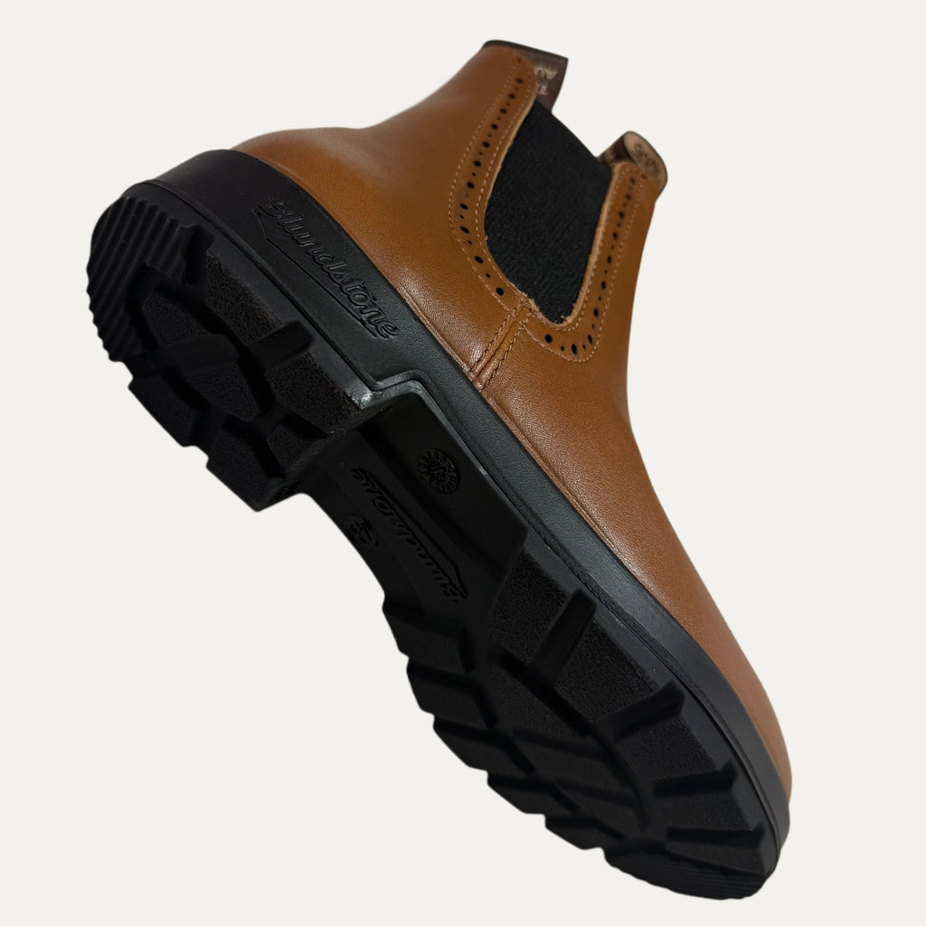 Brown leather shoe with black sole on a white background