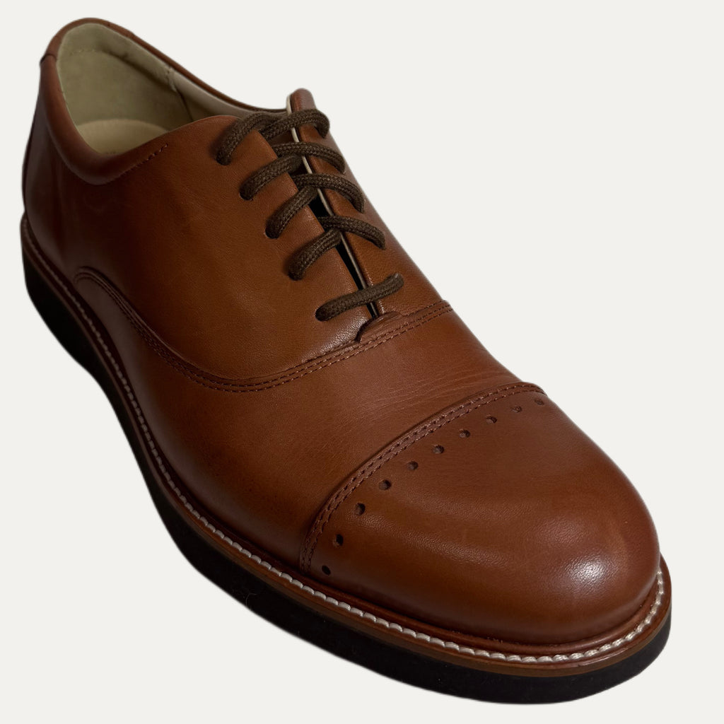 Brown leather dress shoe on a white background