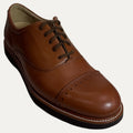 Brown leather dress shoe on a white background