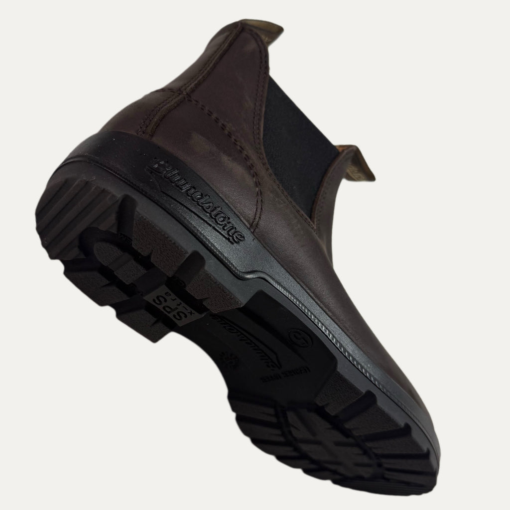 Brown boot shoe with a textured sole on a white background