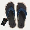 Pair of blue flip flops with a visible brand tag on a white background