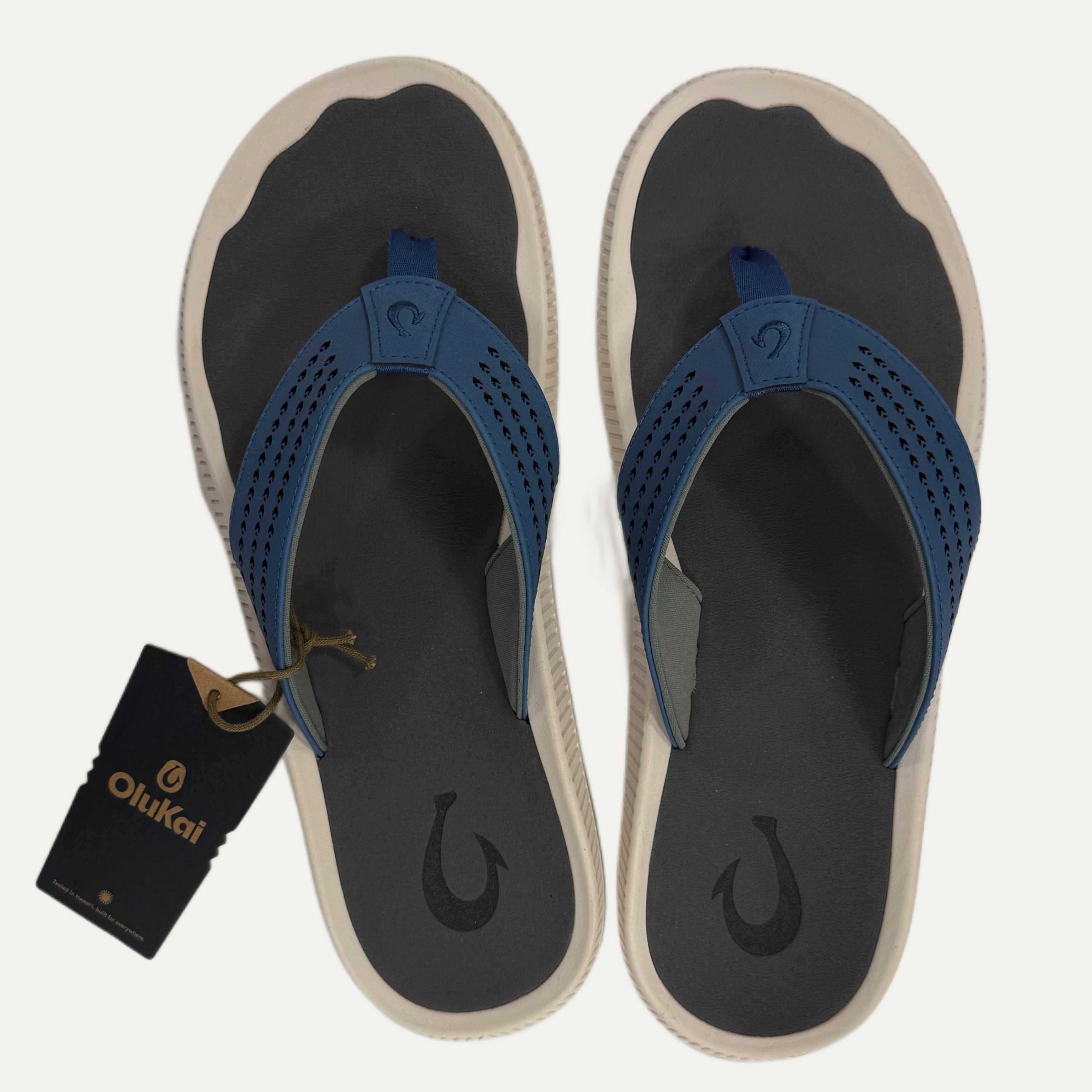 Pair of blue flip flops with a visible brand tag on a white background