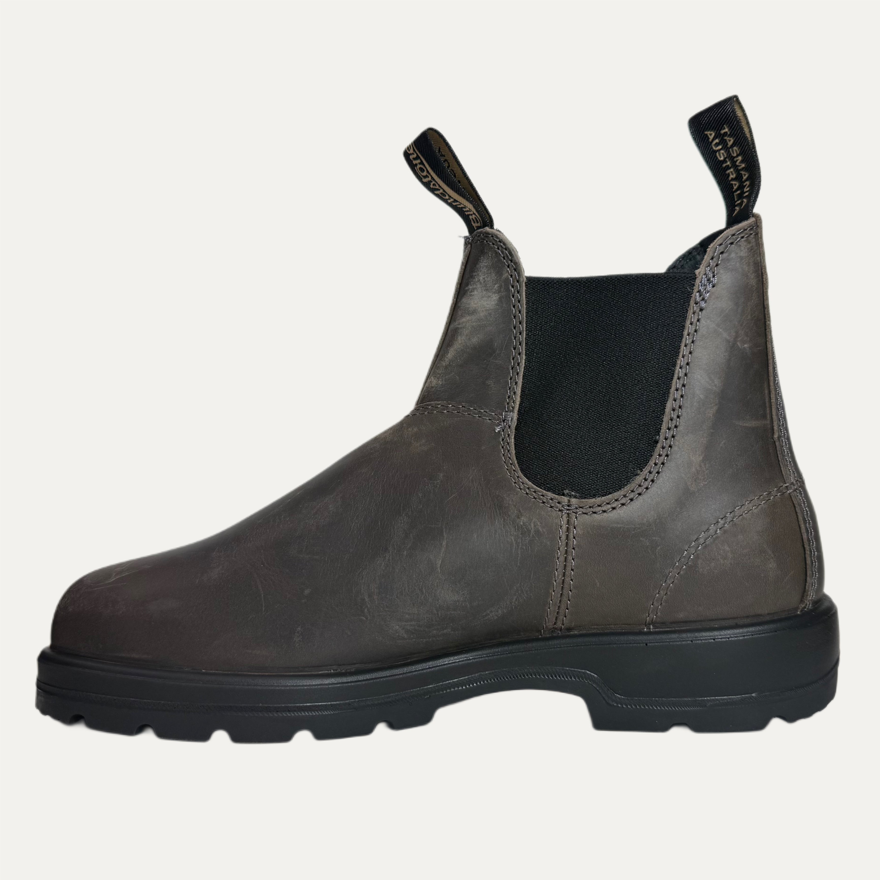 Brown grey leather Chelsea boot with black sole on a light gray background