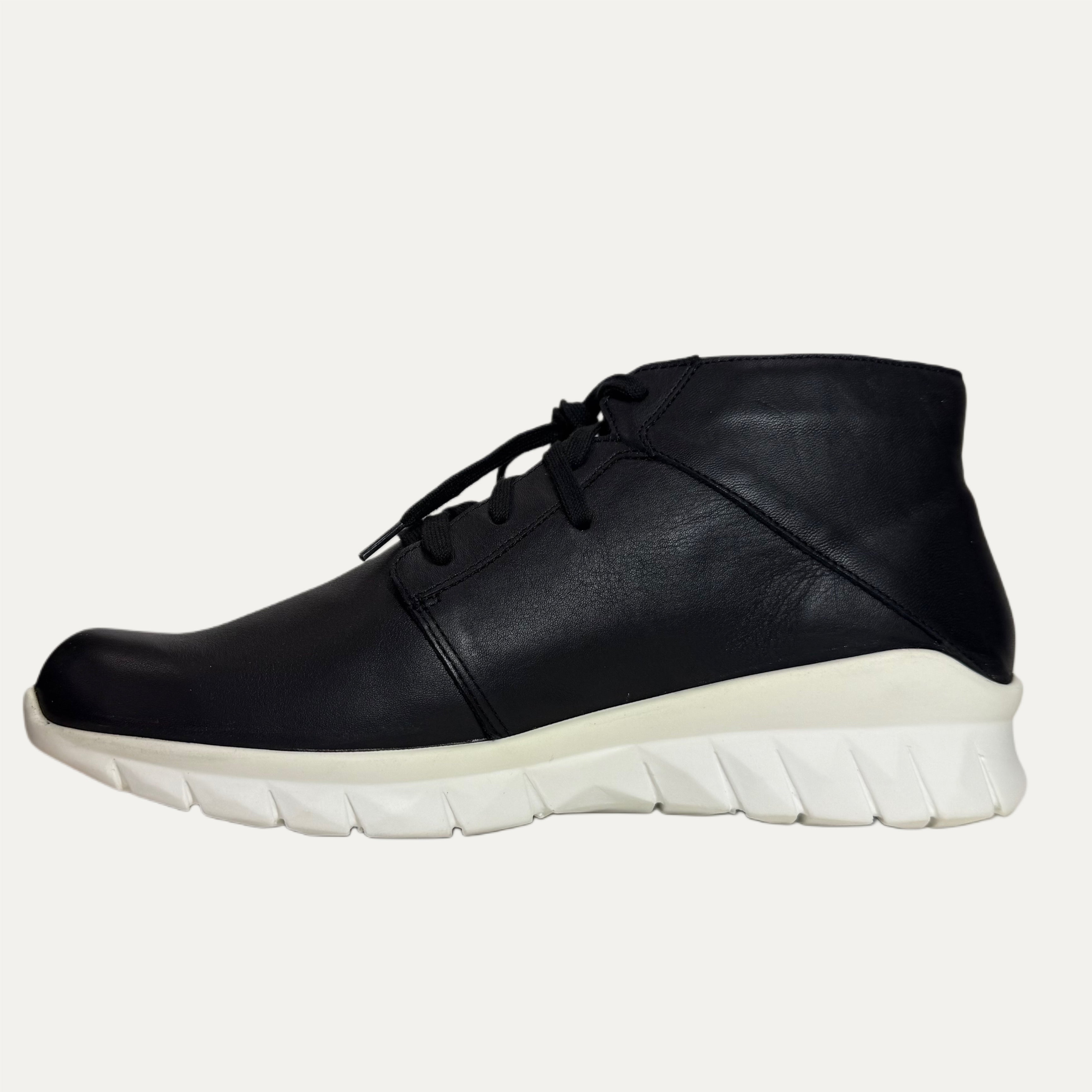 Black leather shoe with white sole on a white background