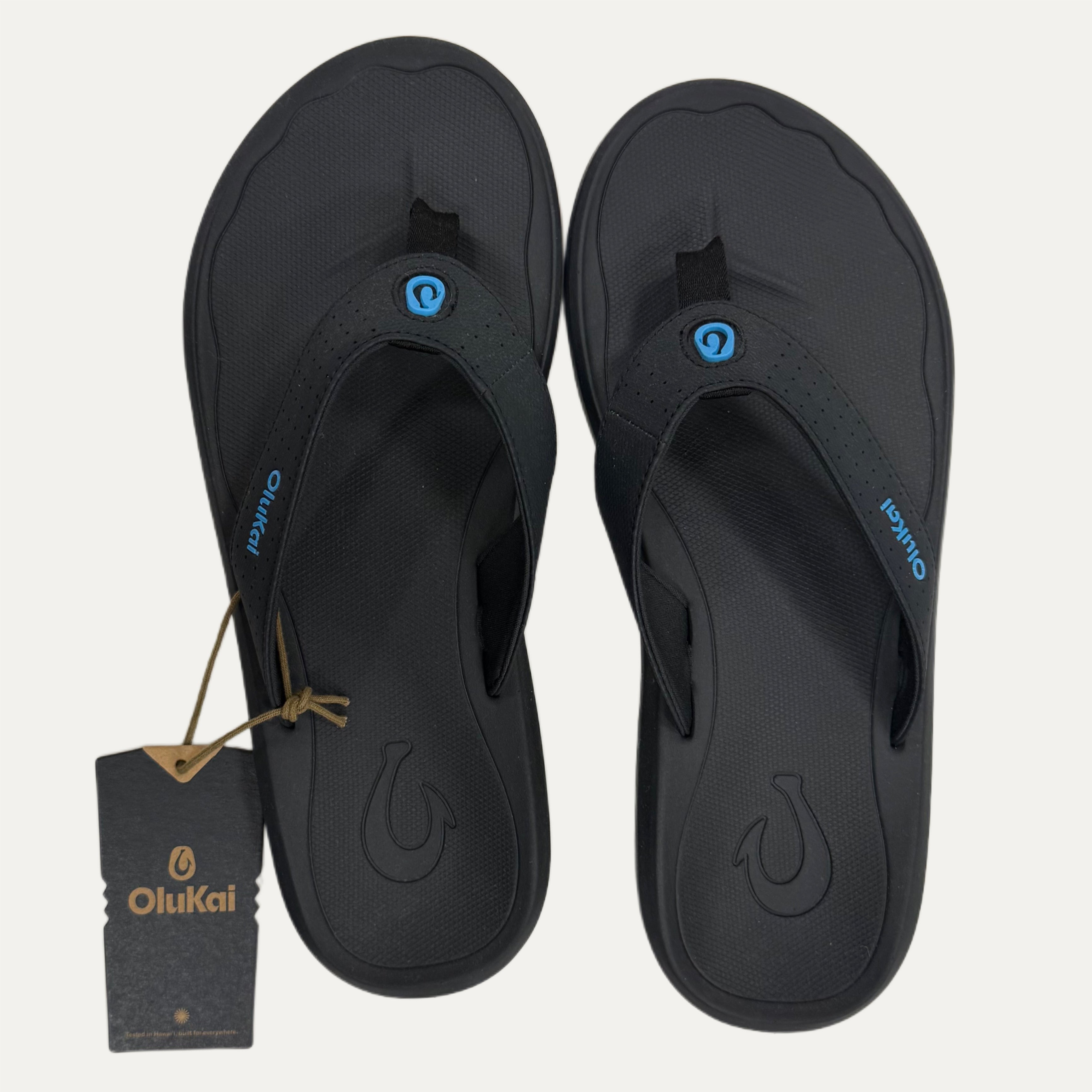 Black flop flops with a visible brand tag on a white background