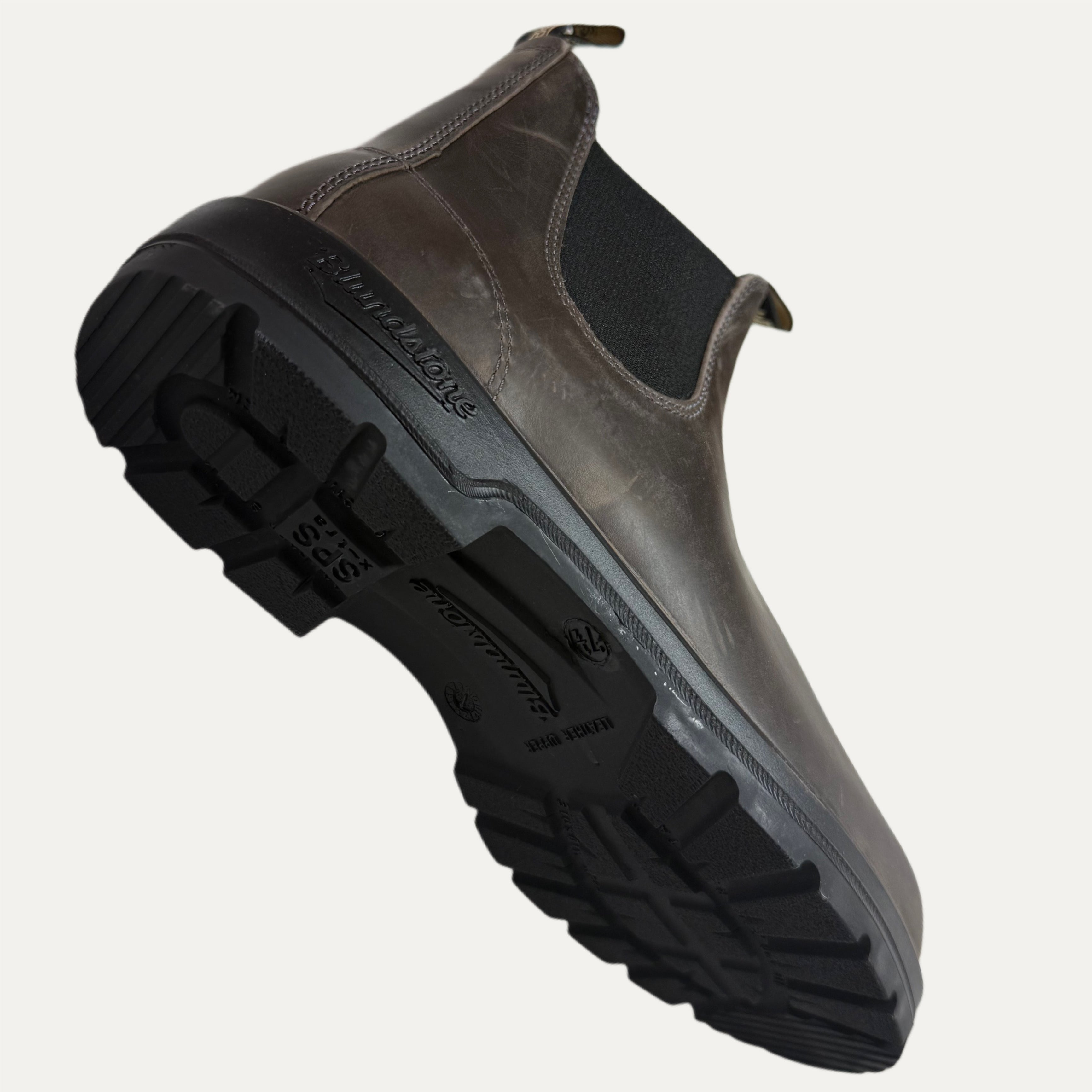 Brown grey chelsea boot with black sole on a white background