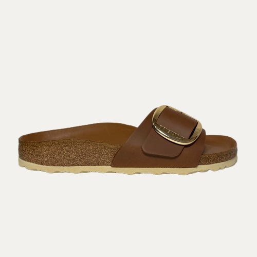 Brown sandal with a gold buckle on a white background