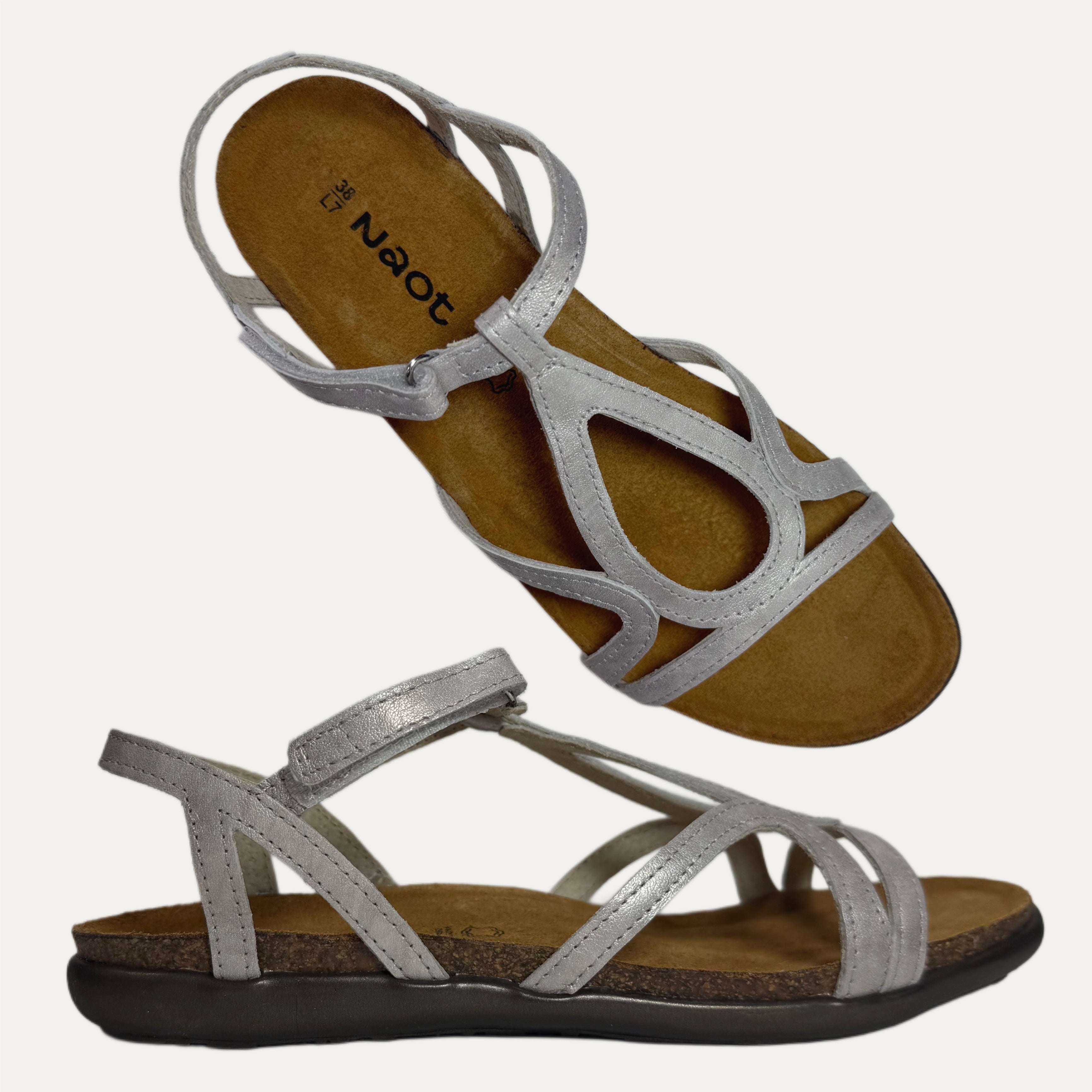 Pair of silver sandals with 'Naot' branding on a white background