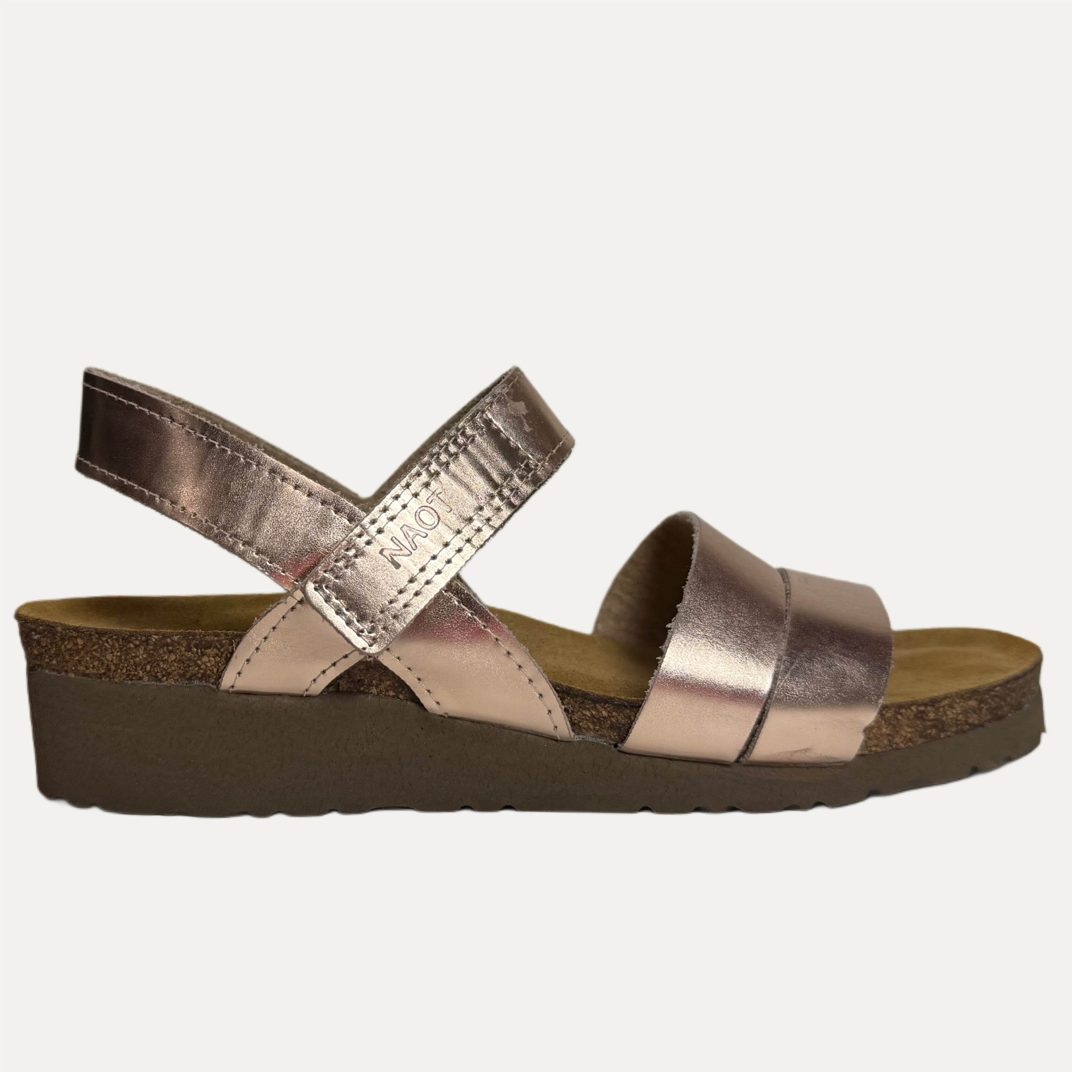 Rose gold sandal with cork insole and black sole on a white background