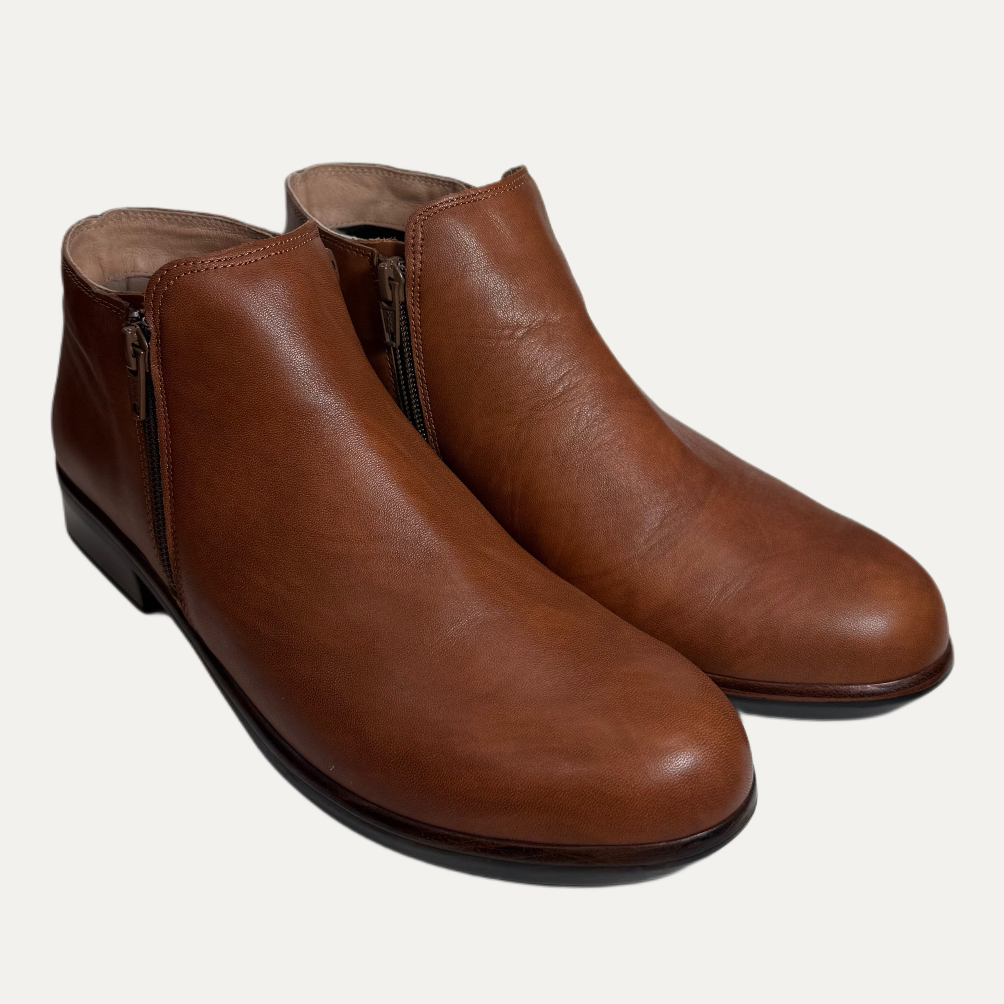 Pair of brown leather ankle boots on a white background