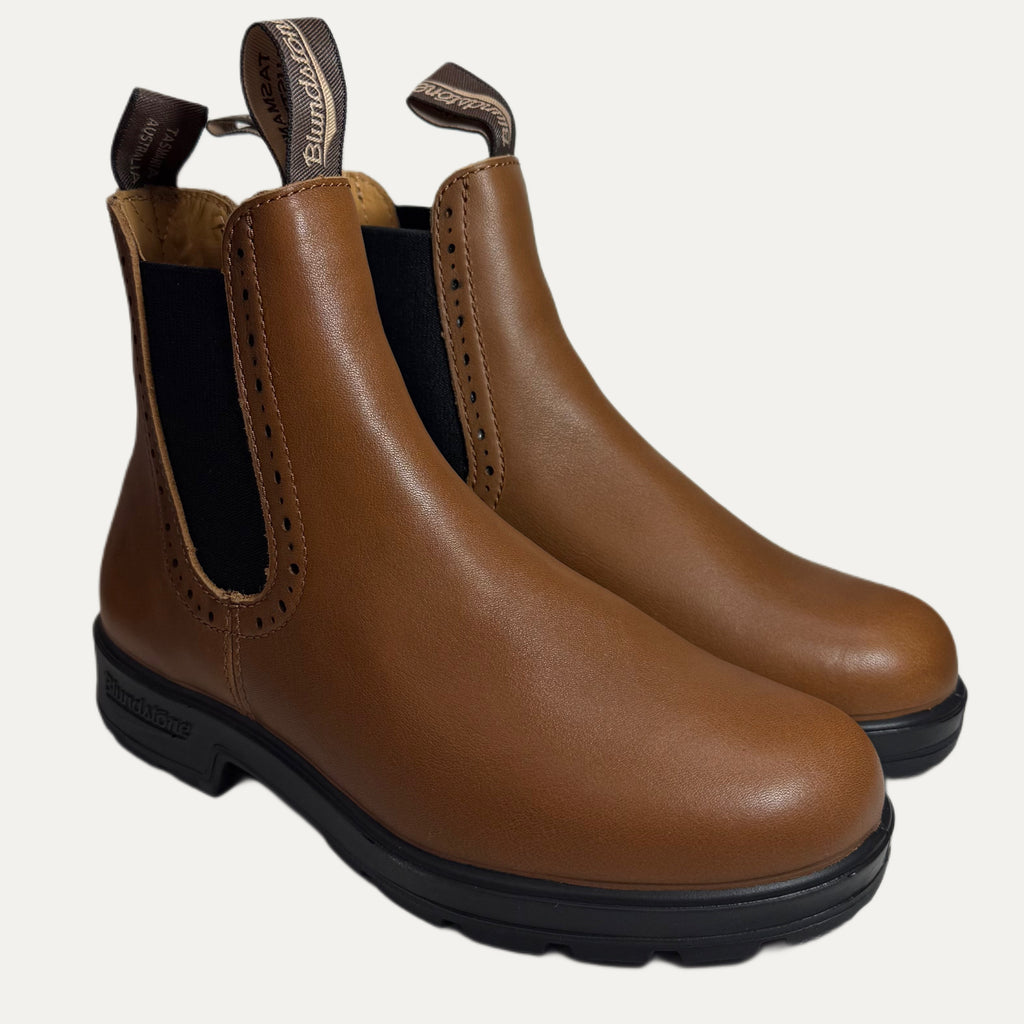 Pair of brown leather boots with black soles on a white background