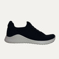 Black sneaker with white sole on a light gray background