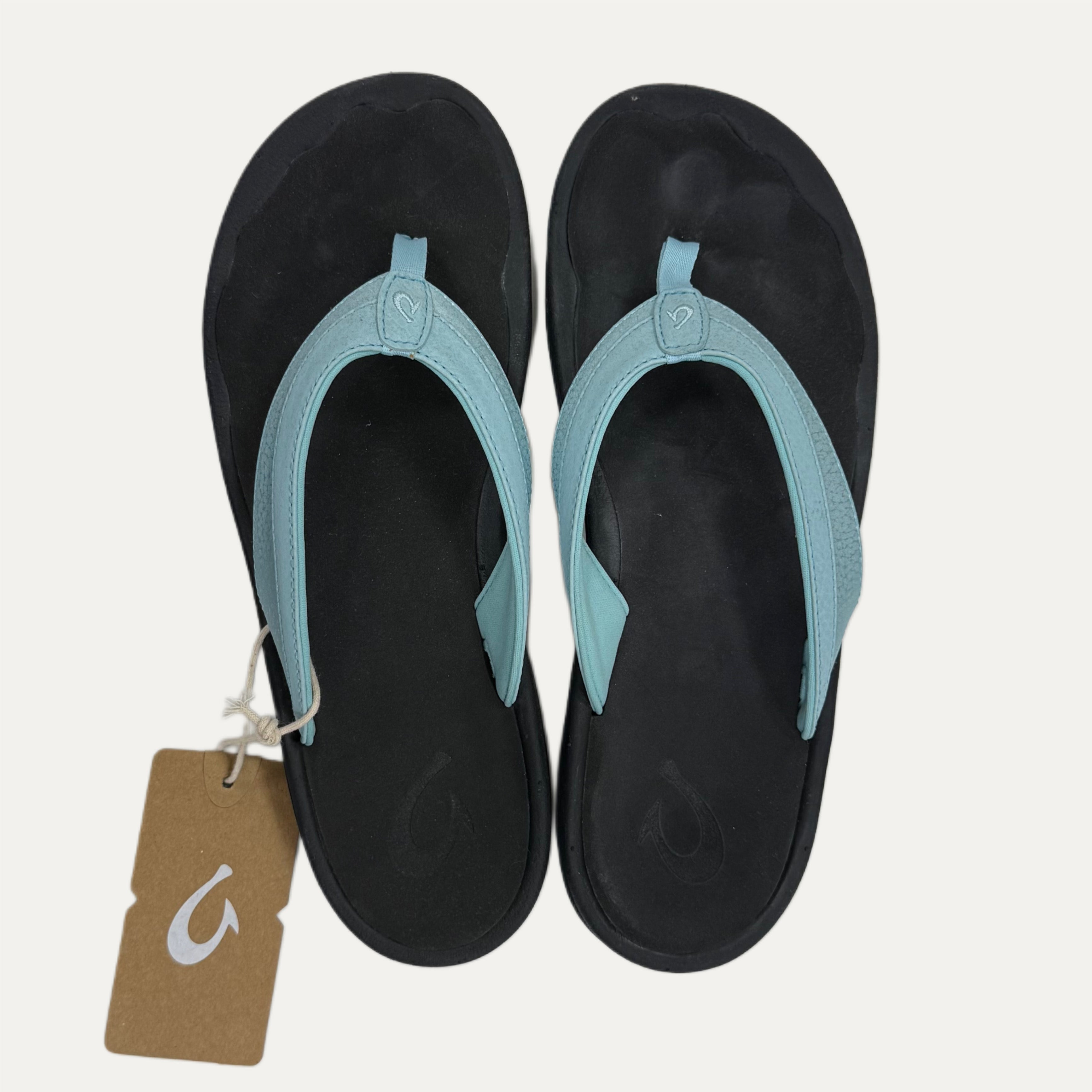 Light blue flip-flops with a brand tag on a white background