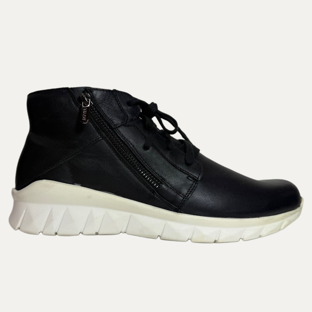 Black leather sneaker with white sole on a light gray background