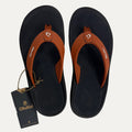 Burnt orange flip flop and a visible brand tag on a white background
