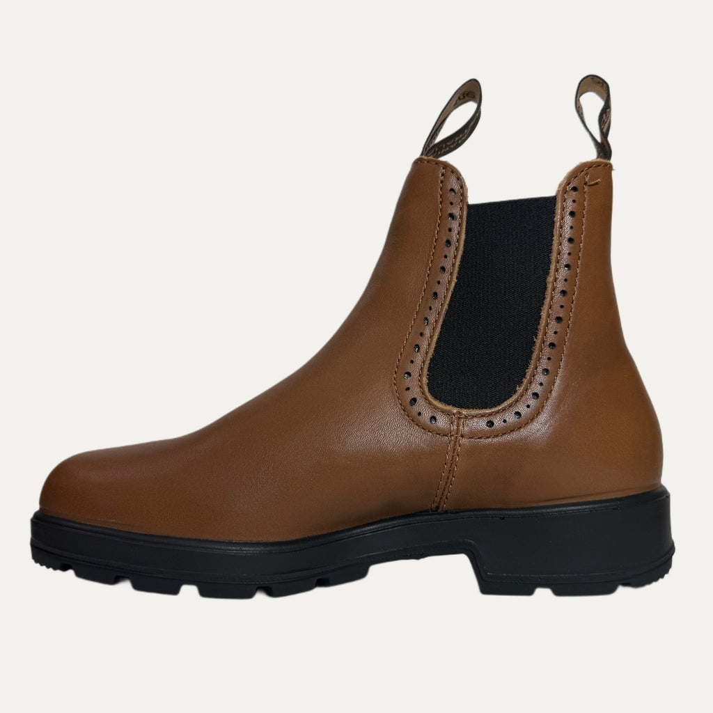Brown leather Chelsea boot with black sole on a light gray background