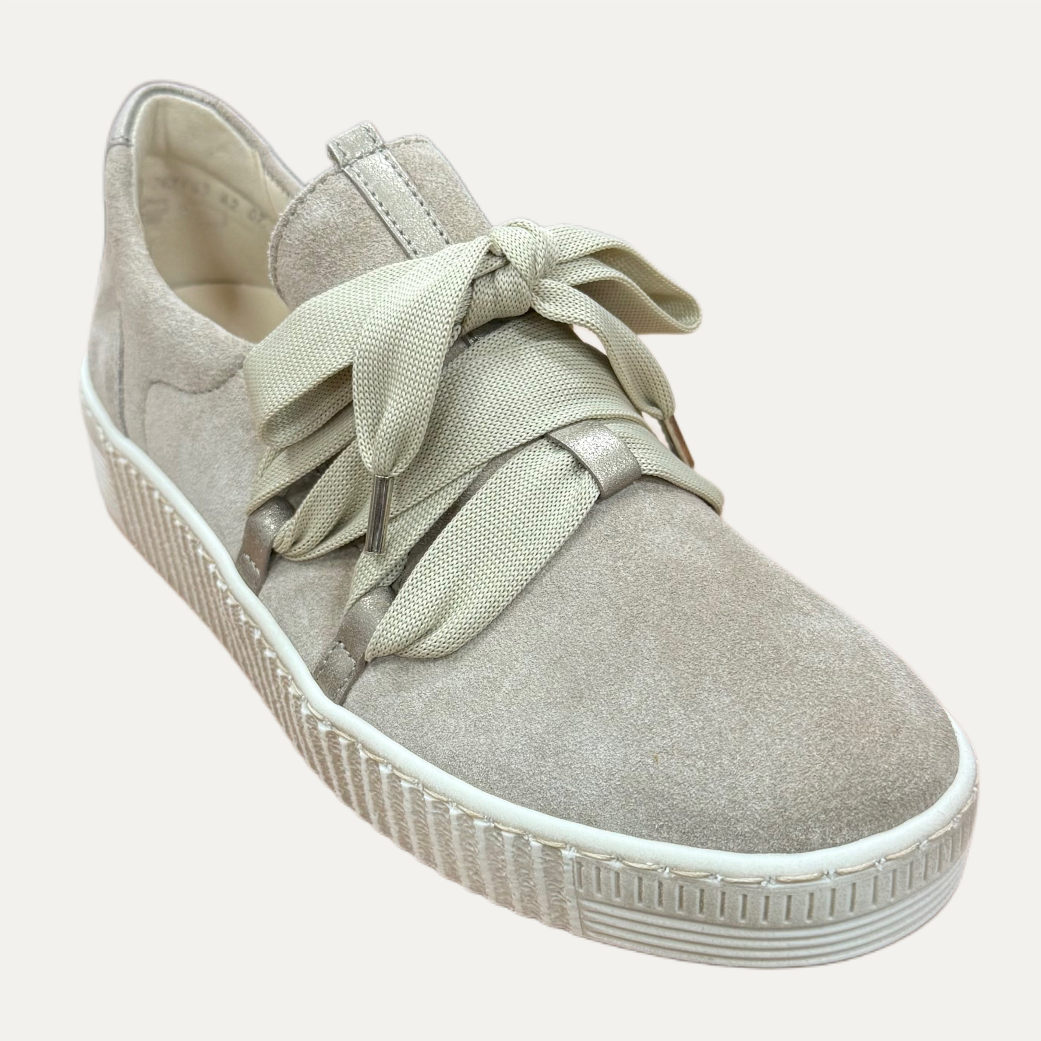 Beige sneaker with bow detail on a white background