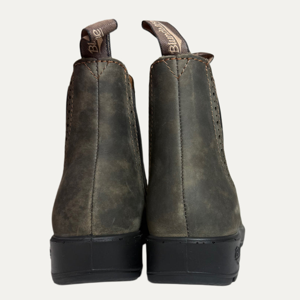 Pair of brown leather boots with black soles on a white background