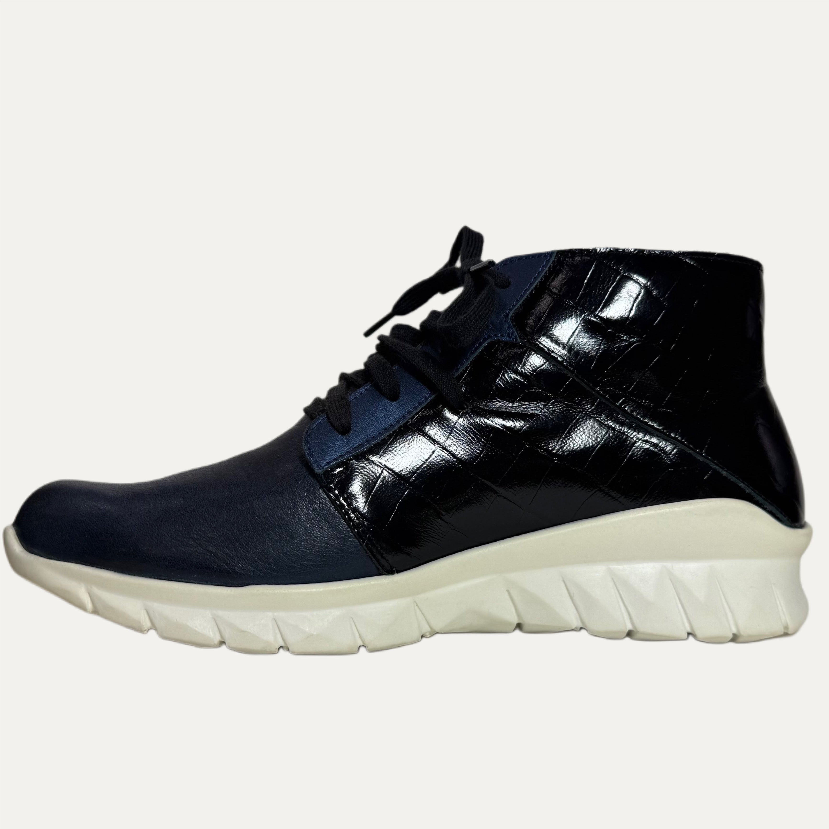 Black high-top sneaker with white sole on a white background