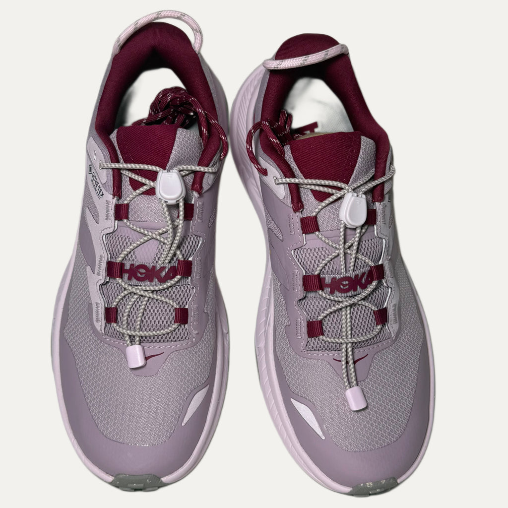 Lilac, red and pink athletic HOKA Transport shoes on white background