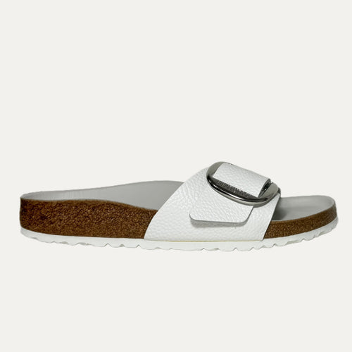 White sandal with brown sole on a white background