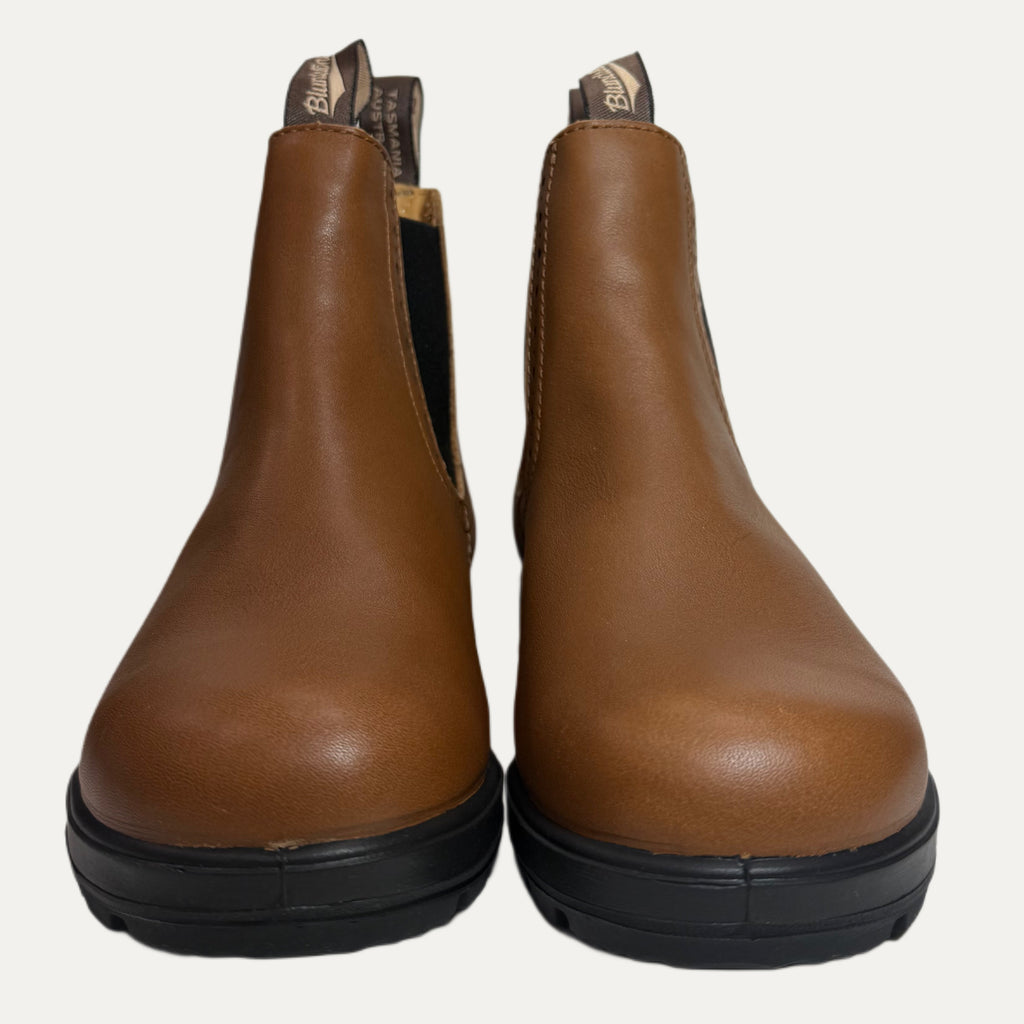 Pair of brown leather boots with black soles on a white background