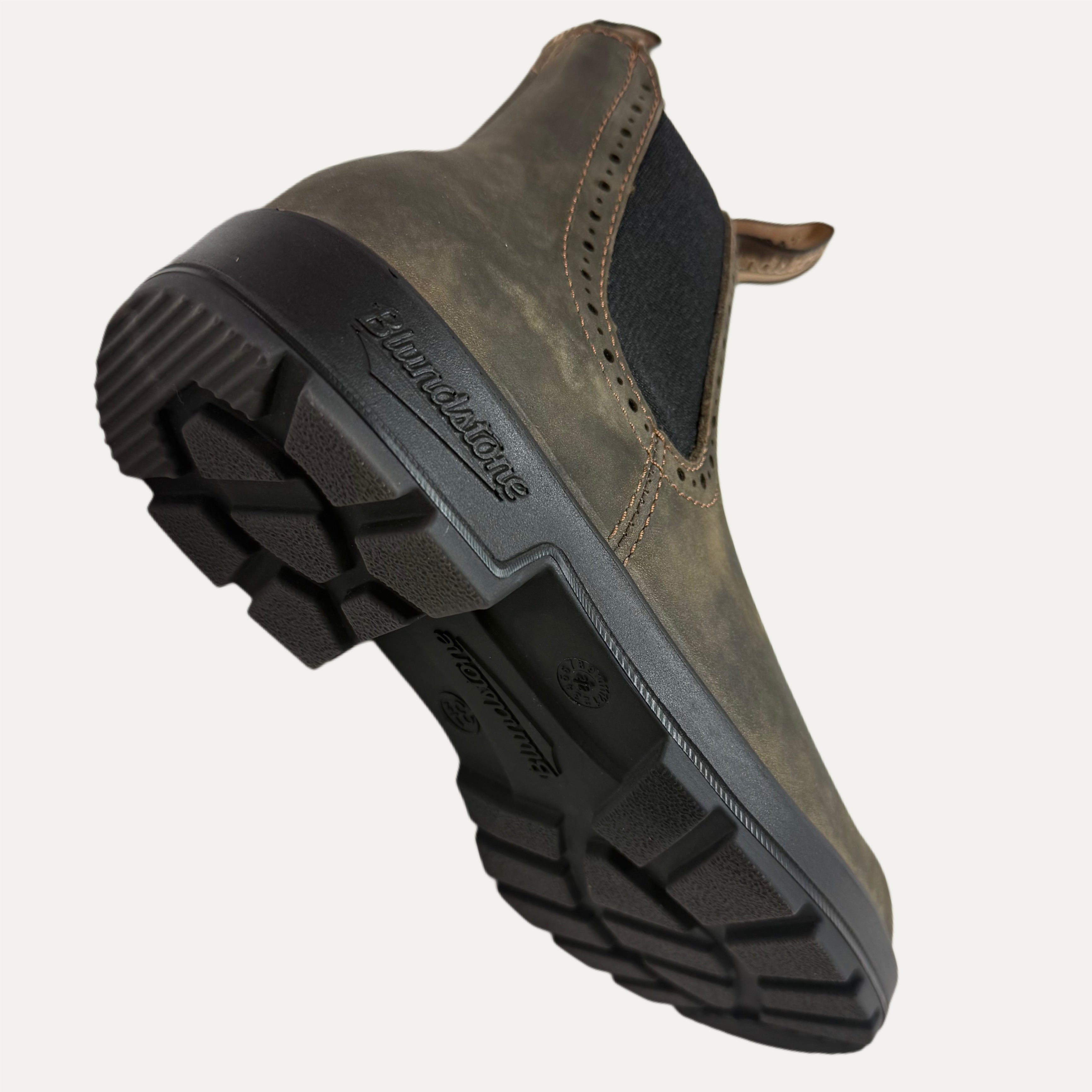 Brown leather shoe with black sole on a white background