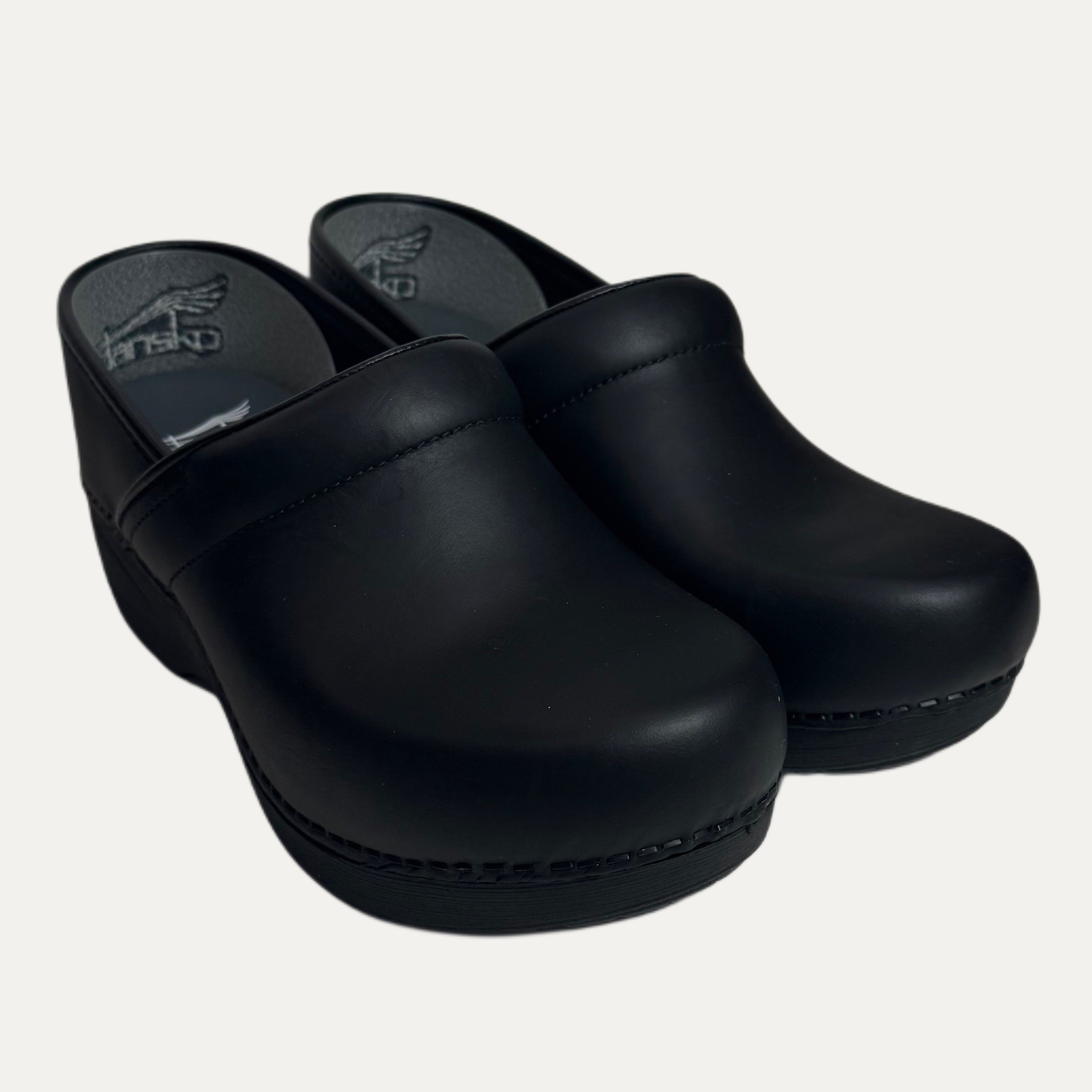 Pair of black leather clogs on a white background