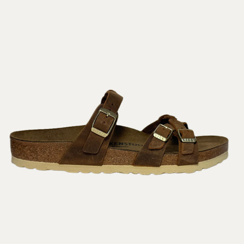 Brown sandal with strap details on a white background