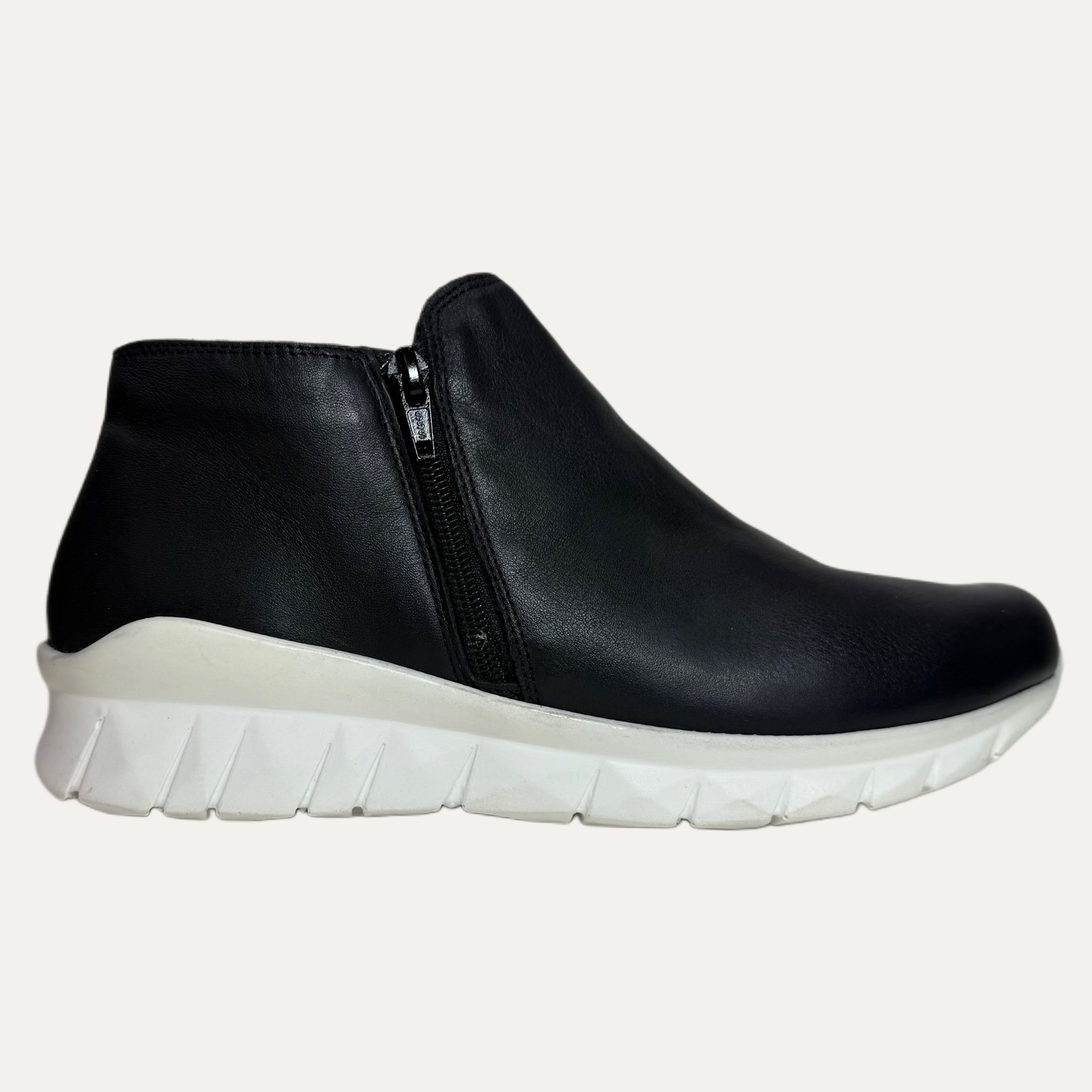 Black ankle boot with a white sole on a white background