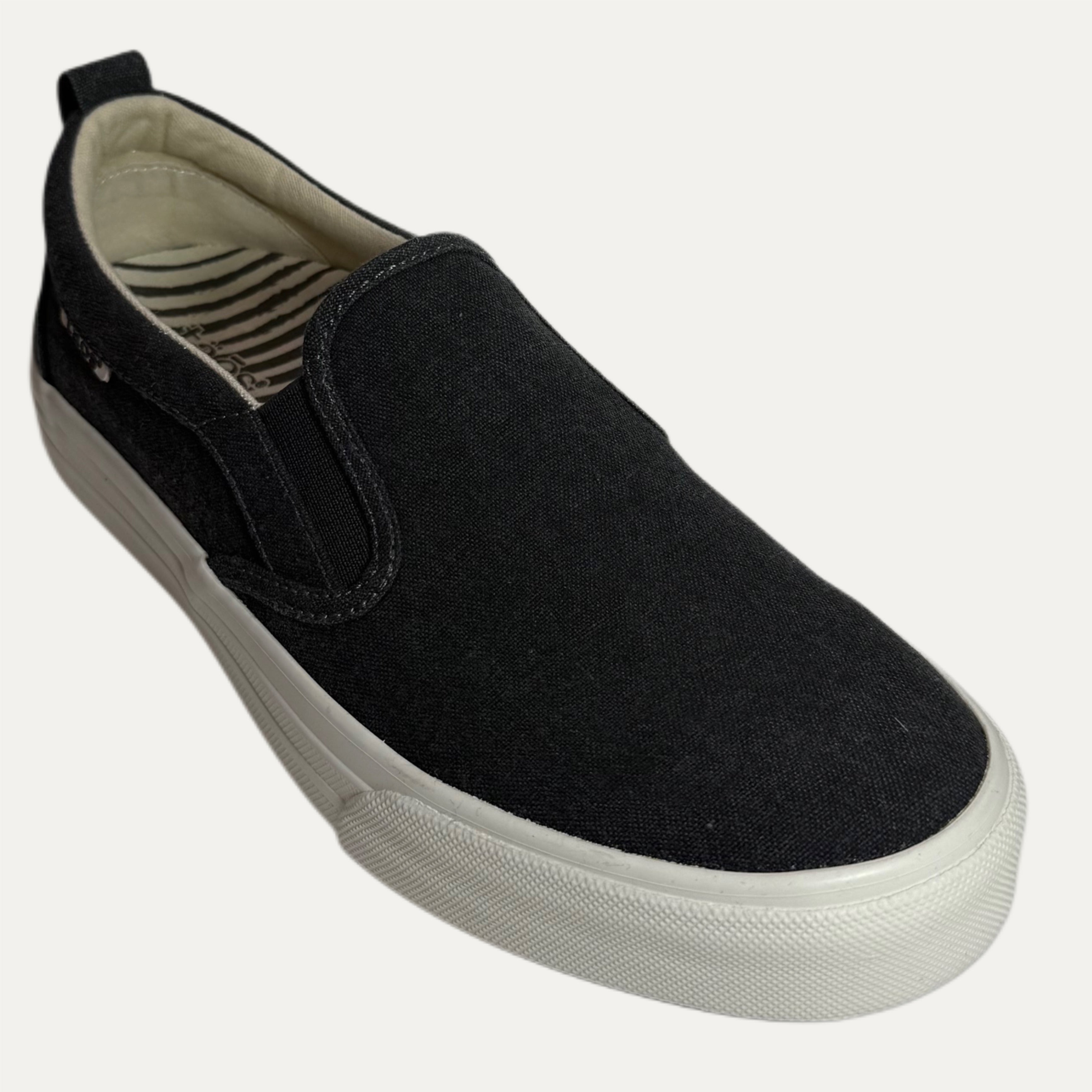 Black slip-on sneaker with a white sole on a white background