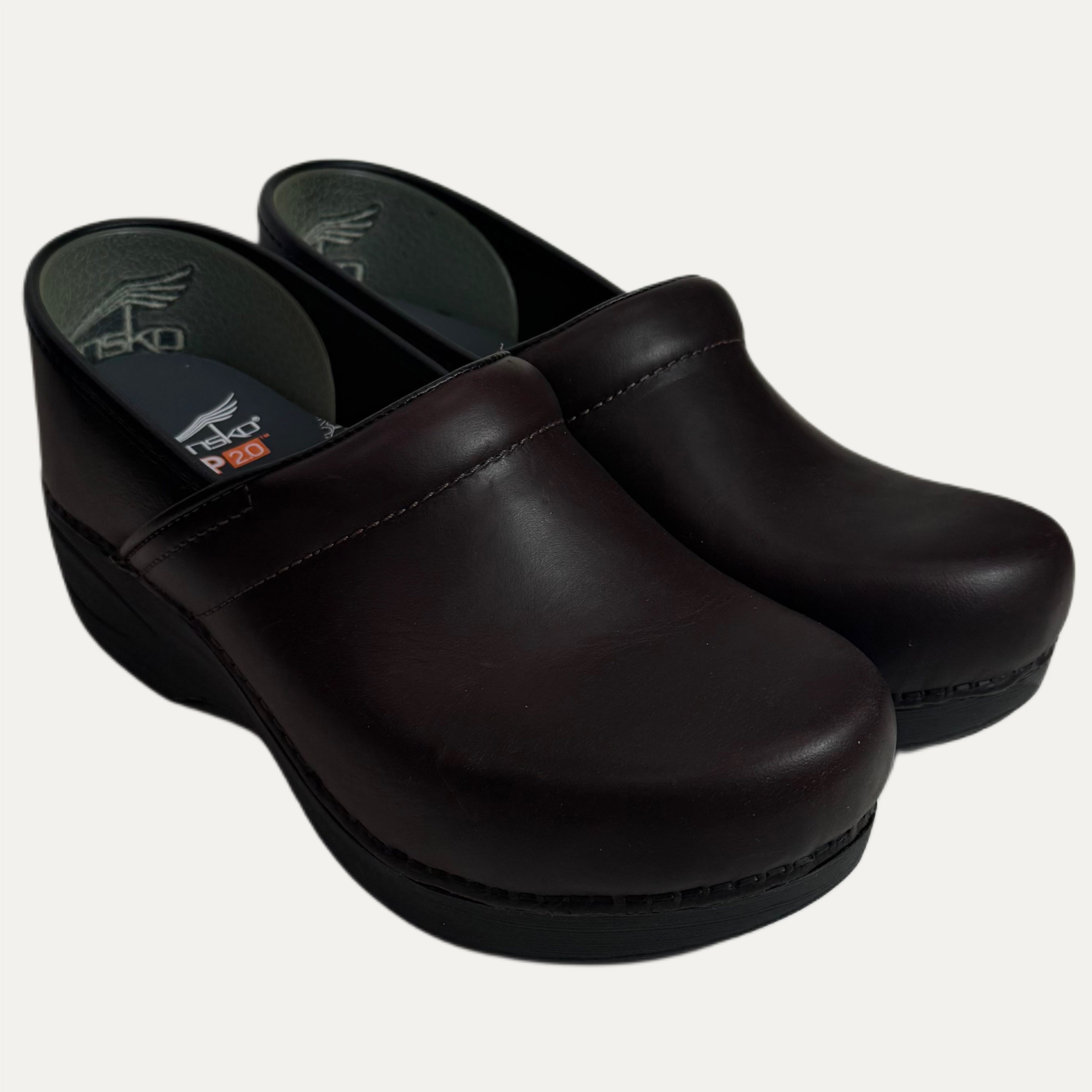 Pair of dark brown clogs on a white background