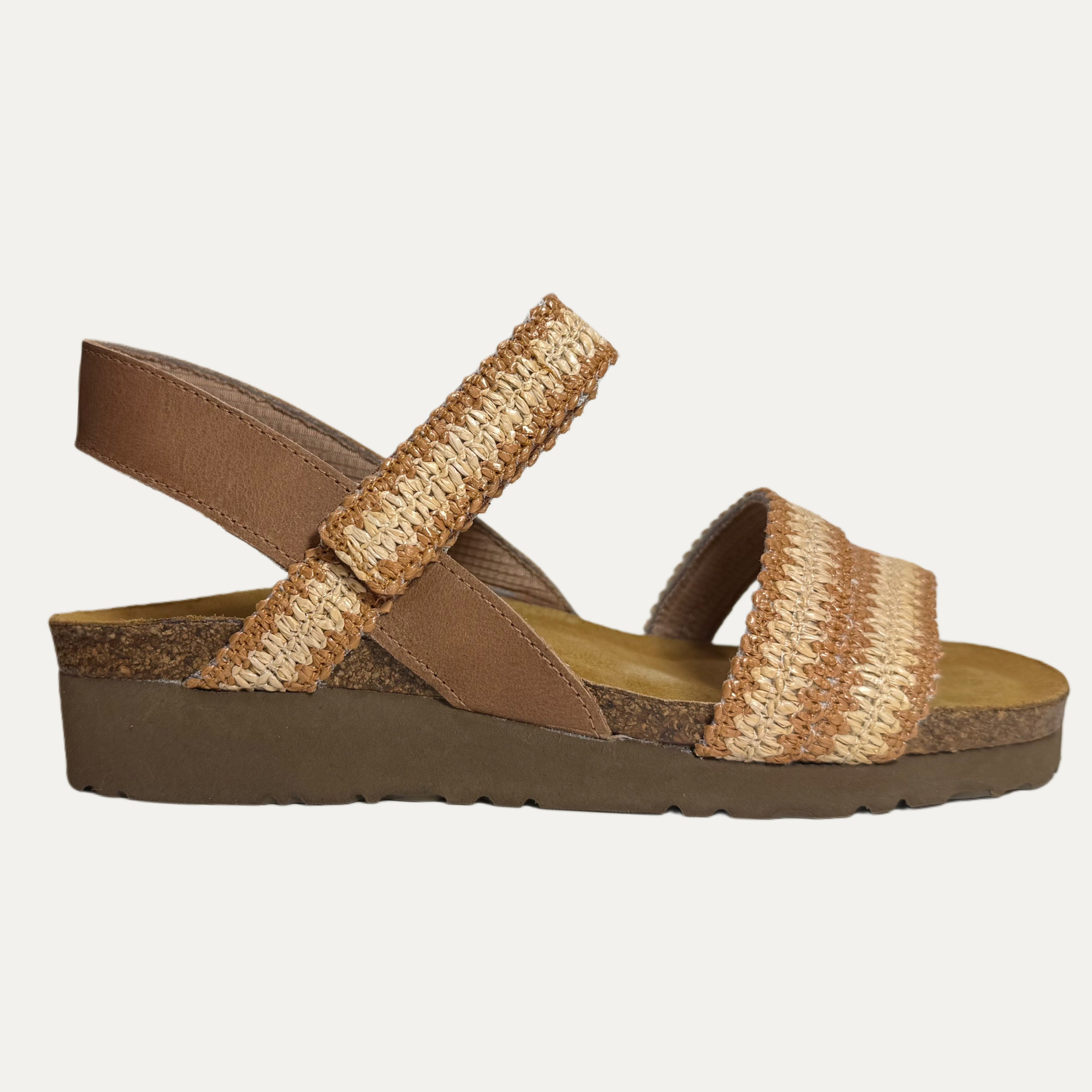 Brown sandal with woven raffia straps and cork sole on a light gray background