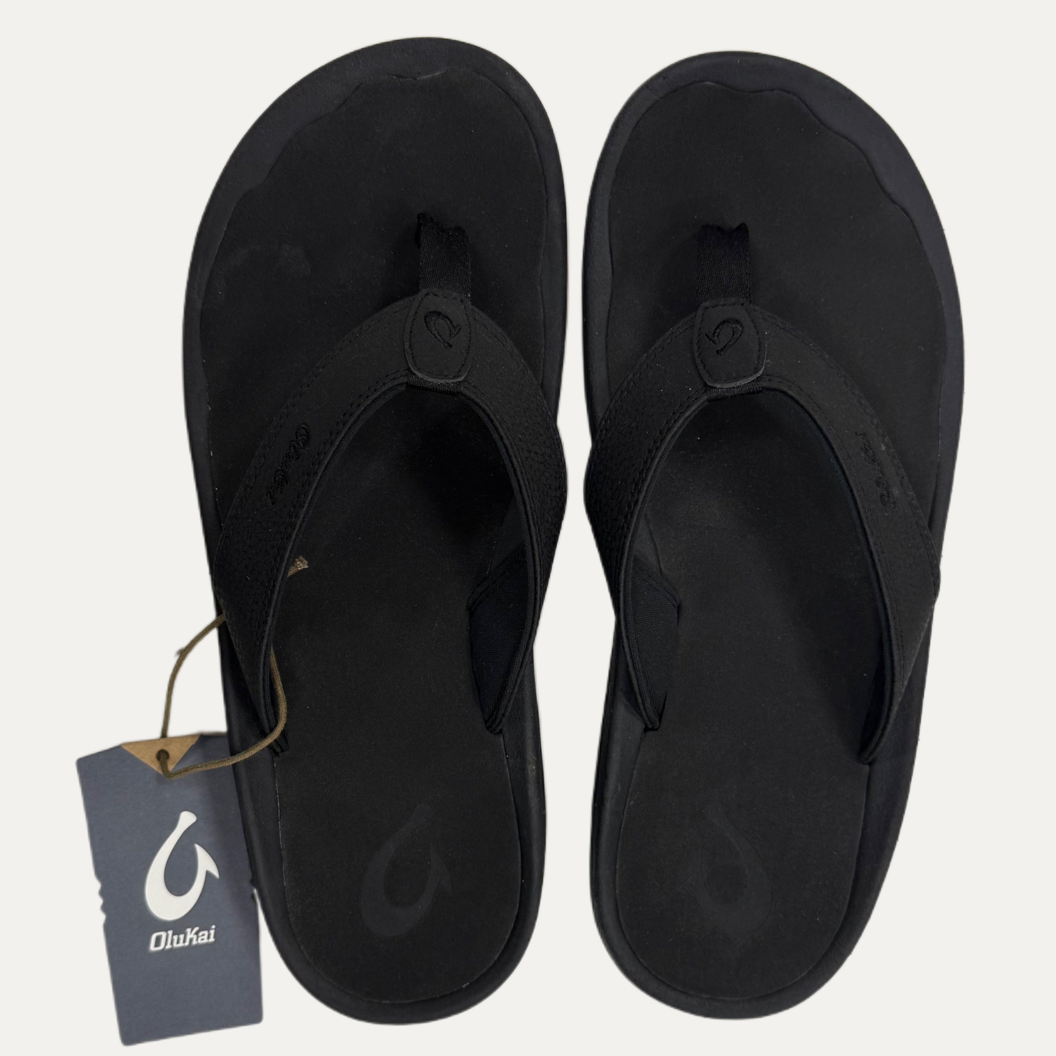 Black flip flops with a brand tag on a white background