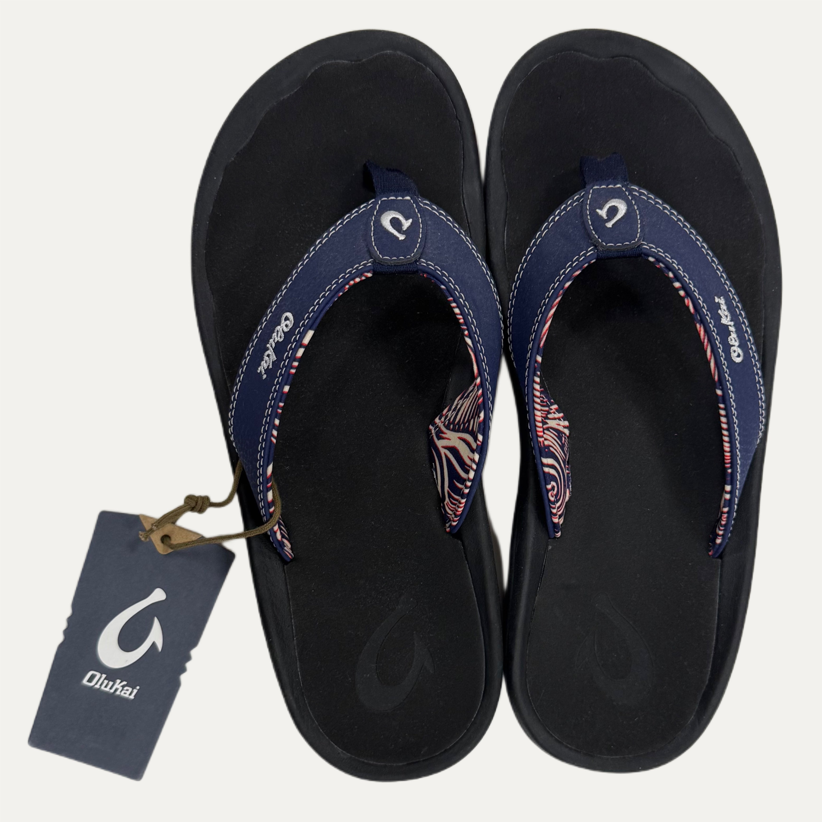 A pair of Blue flip flops and a visible brand tag on a white background