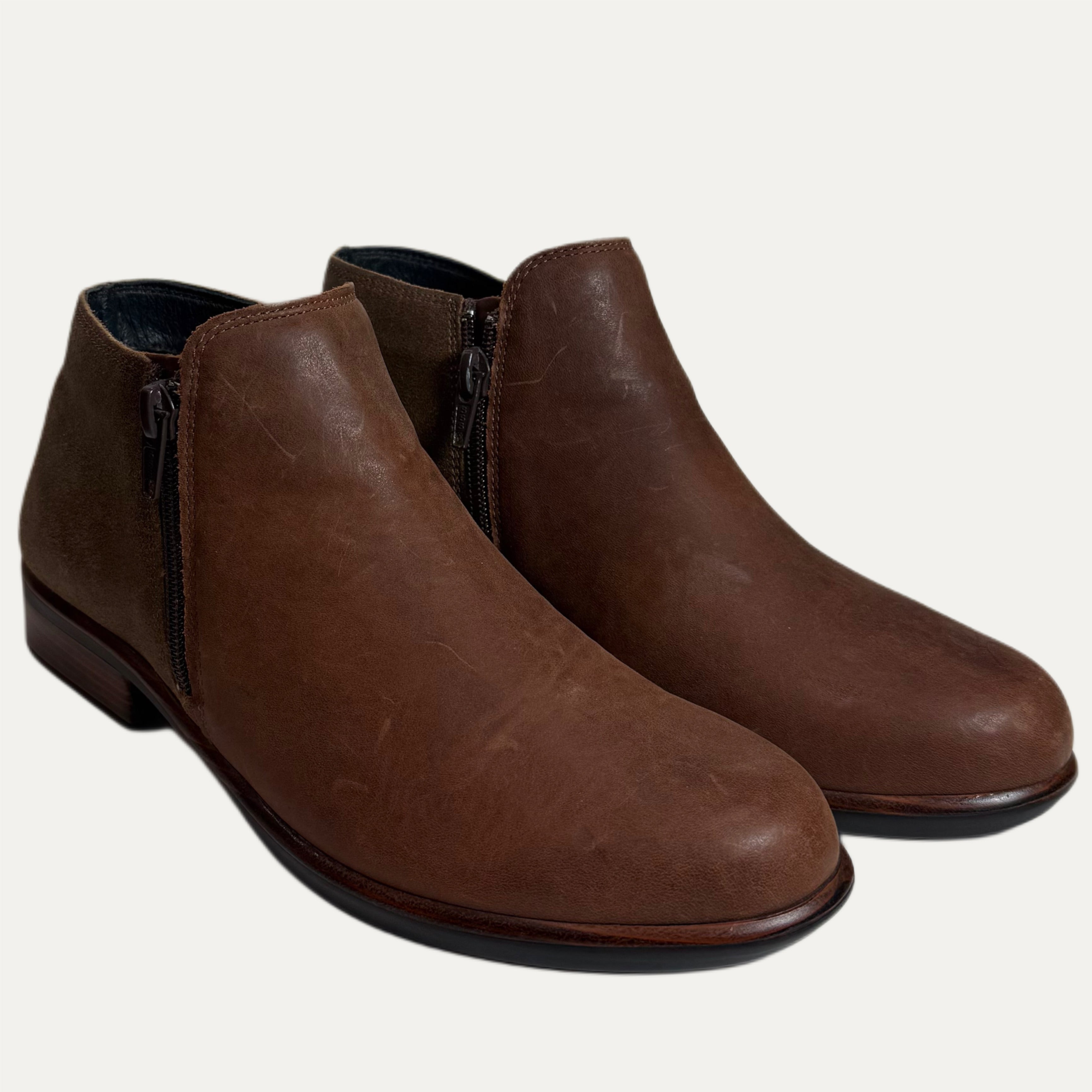 Pair of brown leather ankle boots on a white background